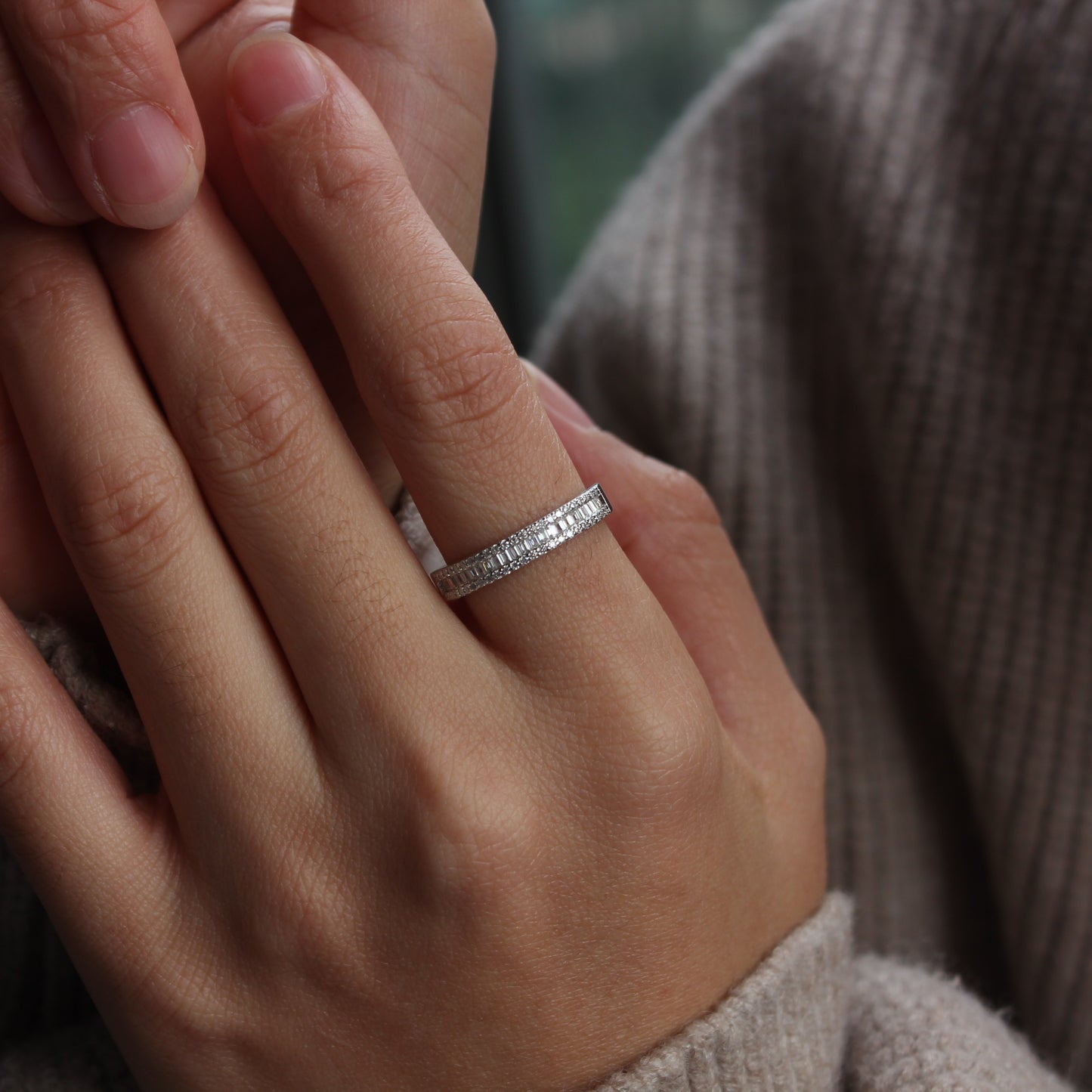 Baguette pavé moissanite band ring in white gold tone worn on hand, minimalist style