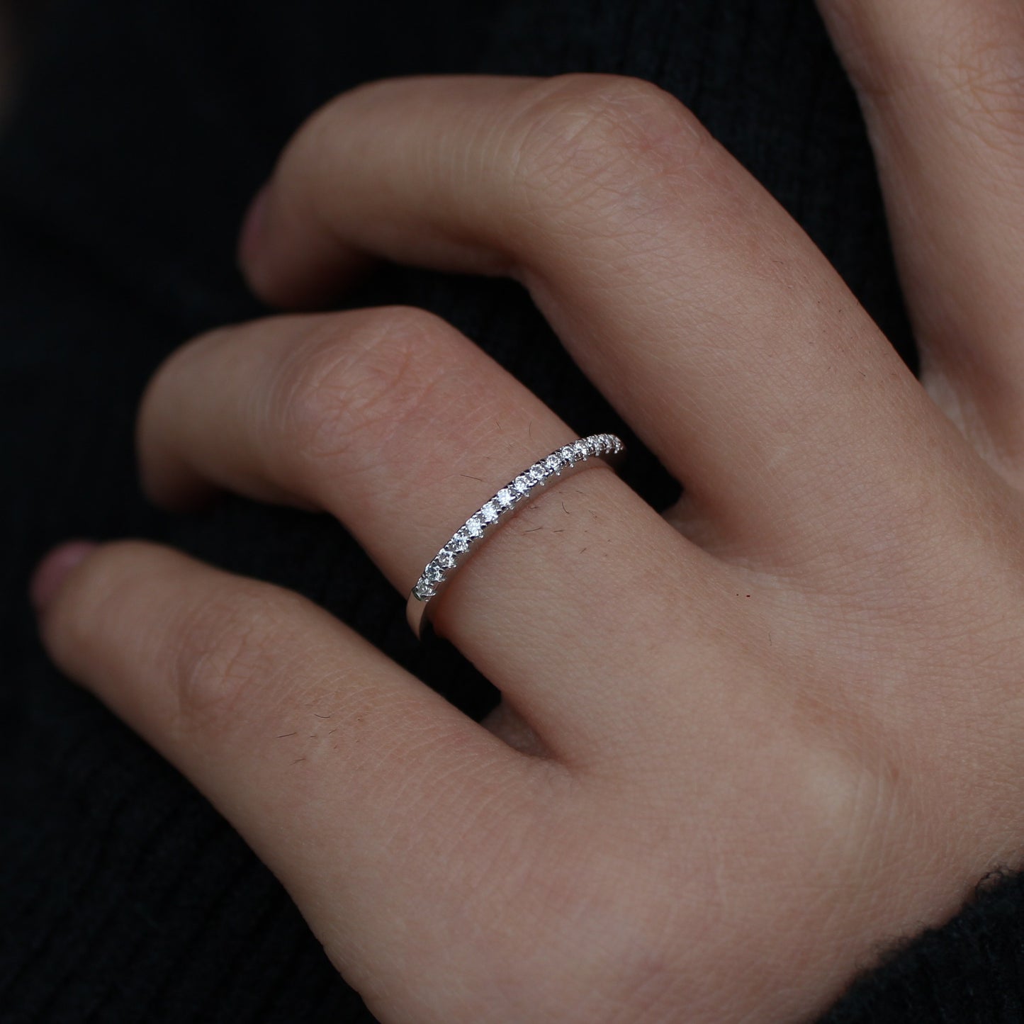 Micro pavé moissanite band close-up on hand, silver tone