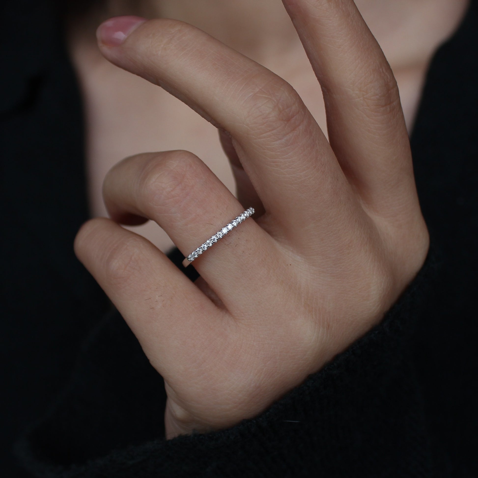 Moissanite pavé band worn on hand, dark background