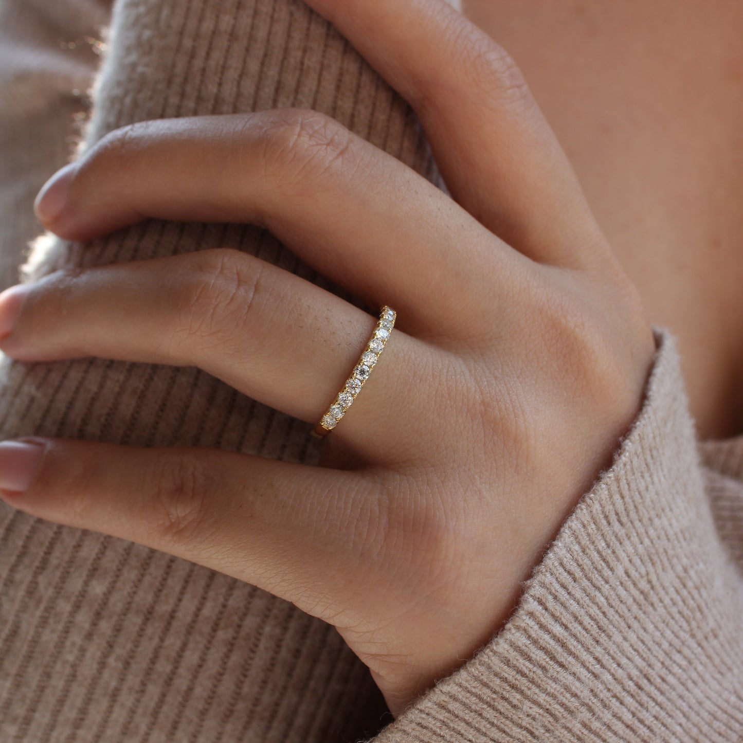 Micro pavé moissanite band worn on finger, close-up