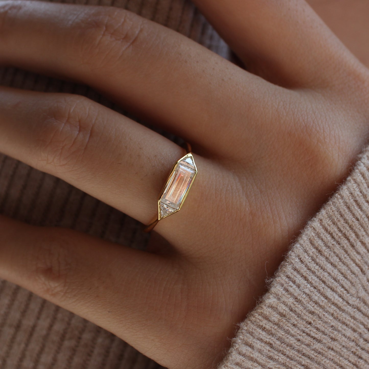 Minimal emerald moissanite bezel ring worn on finger, gold plated sterling silver