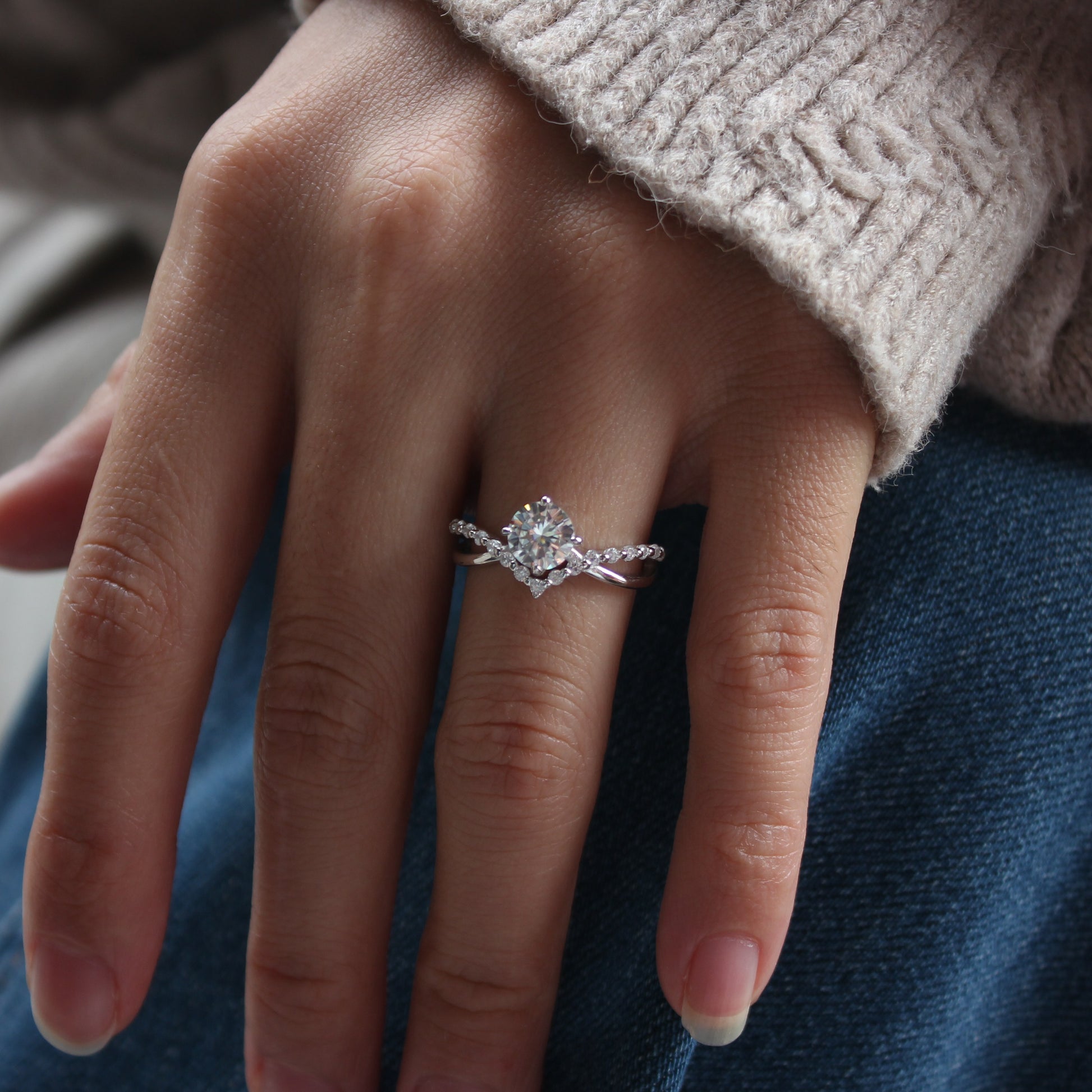 Close-up of Auriel curved moissanite ring worn on hand, white gold tone