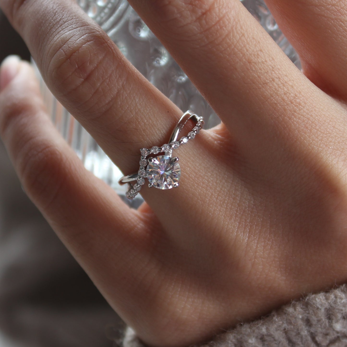 Curved moissanite ring on hand, white gold tone with soft sparkle