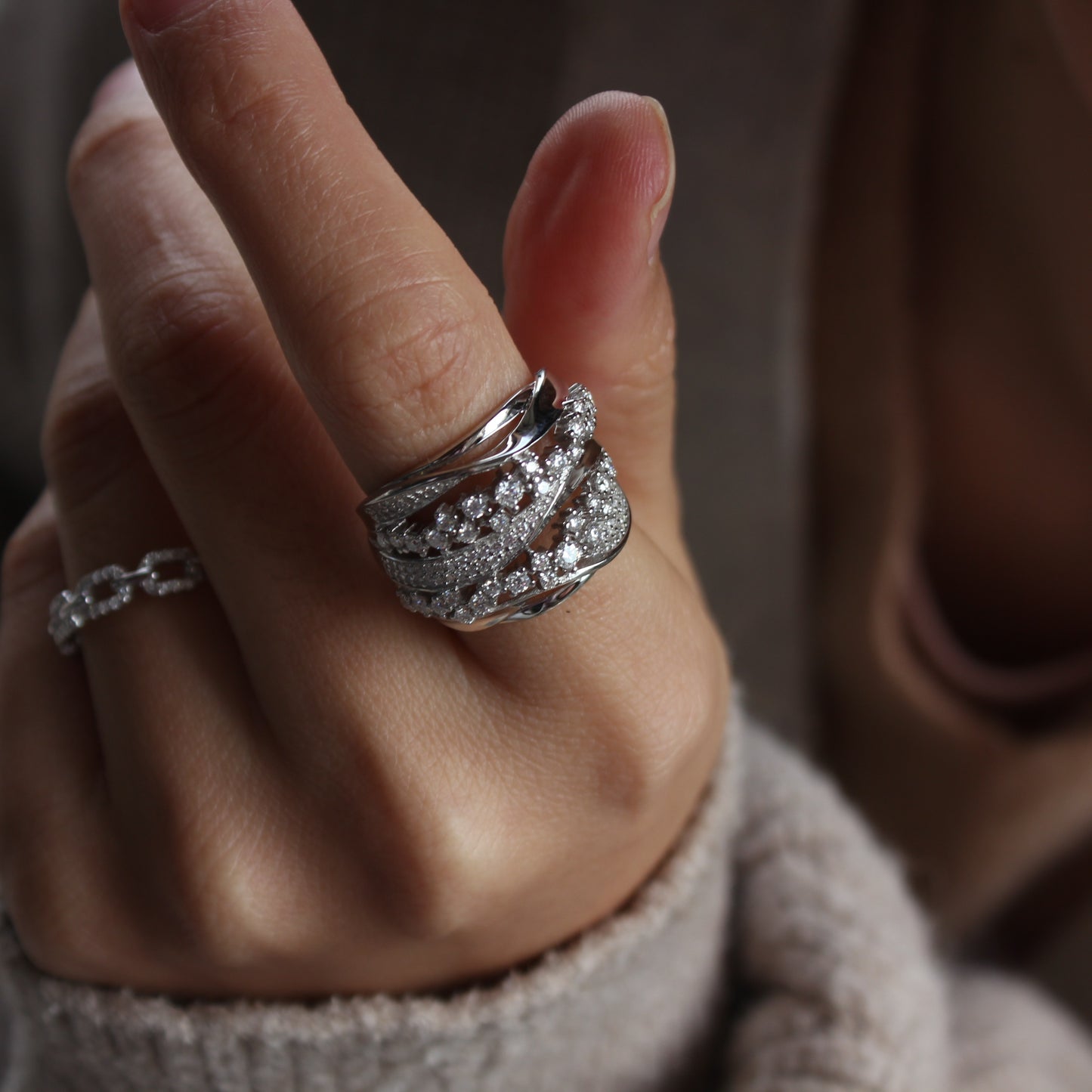 Woman wearing Aurora pavé moissanite band ring in white gold tone, soft sparkle on hand