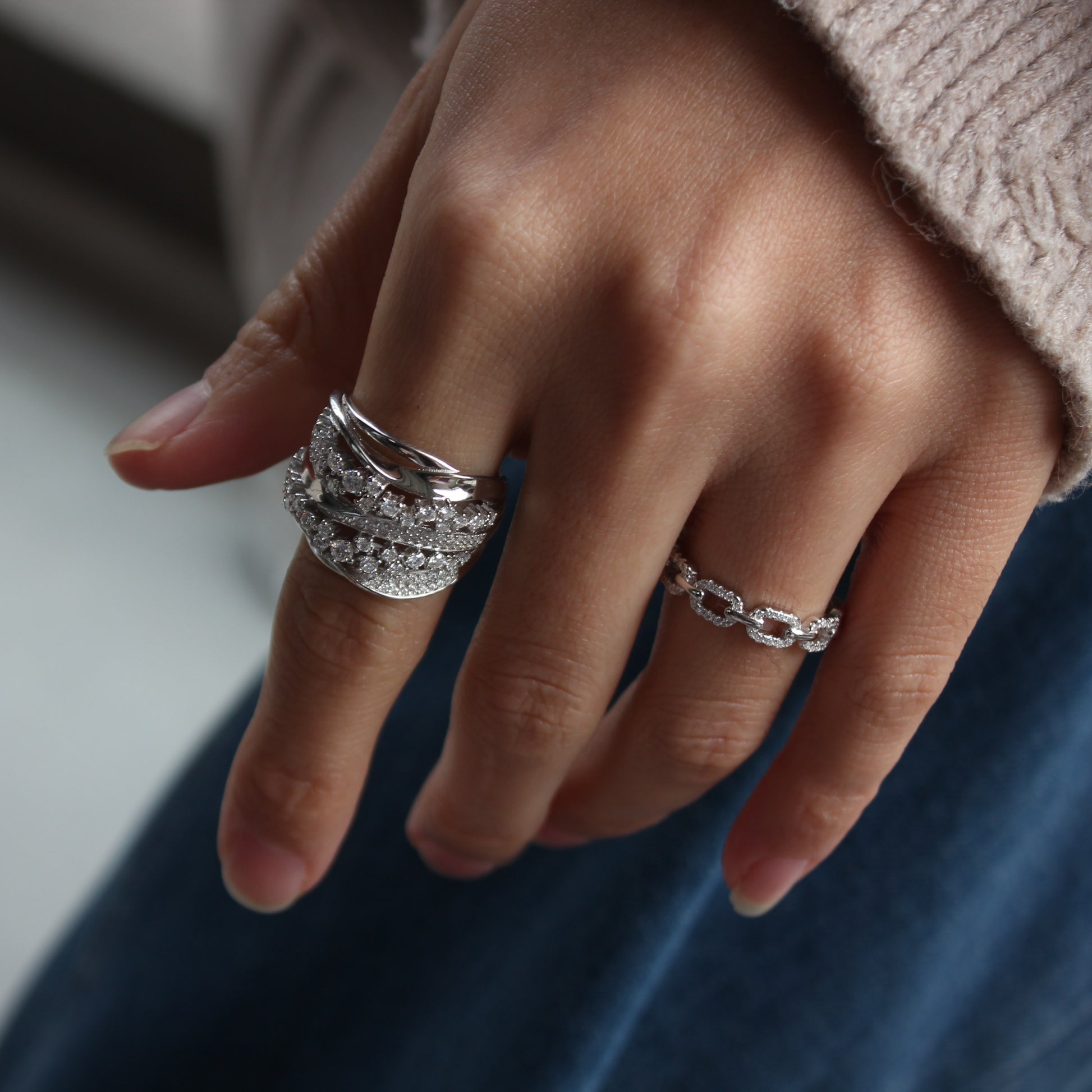 Soft feminine styling of Aurora pavé ring worn on finger