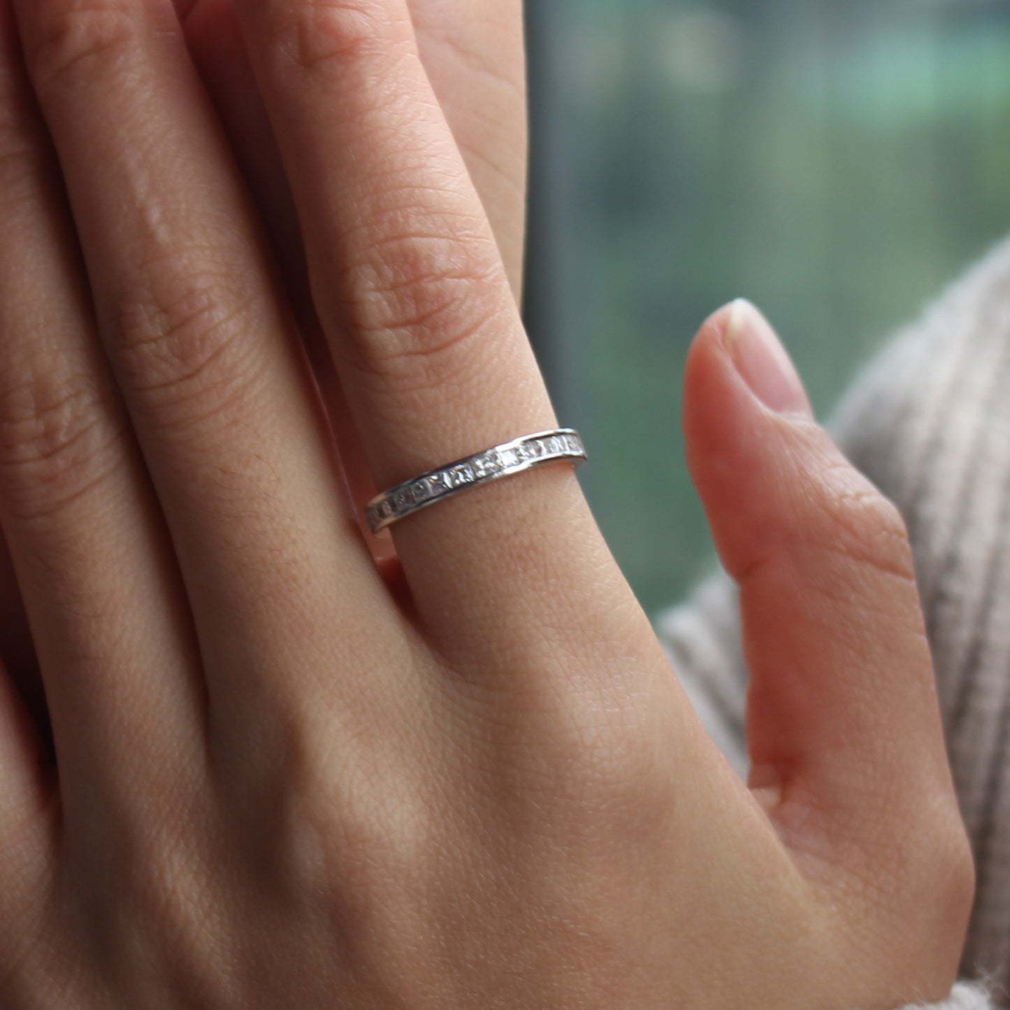 Baguette channel moissanite ring styled on hand, white gold tone for everyday wear
