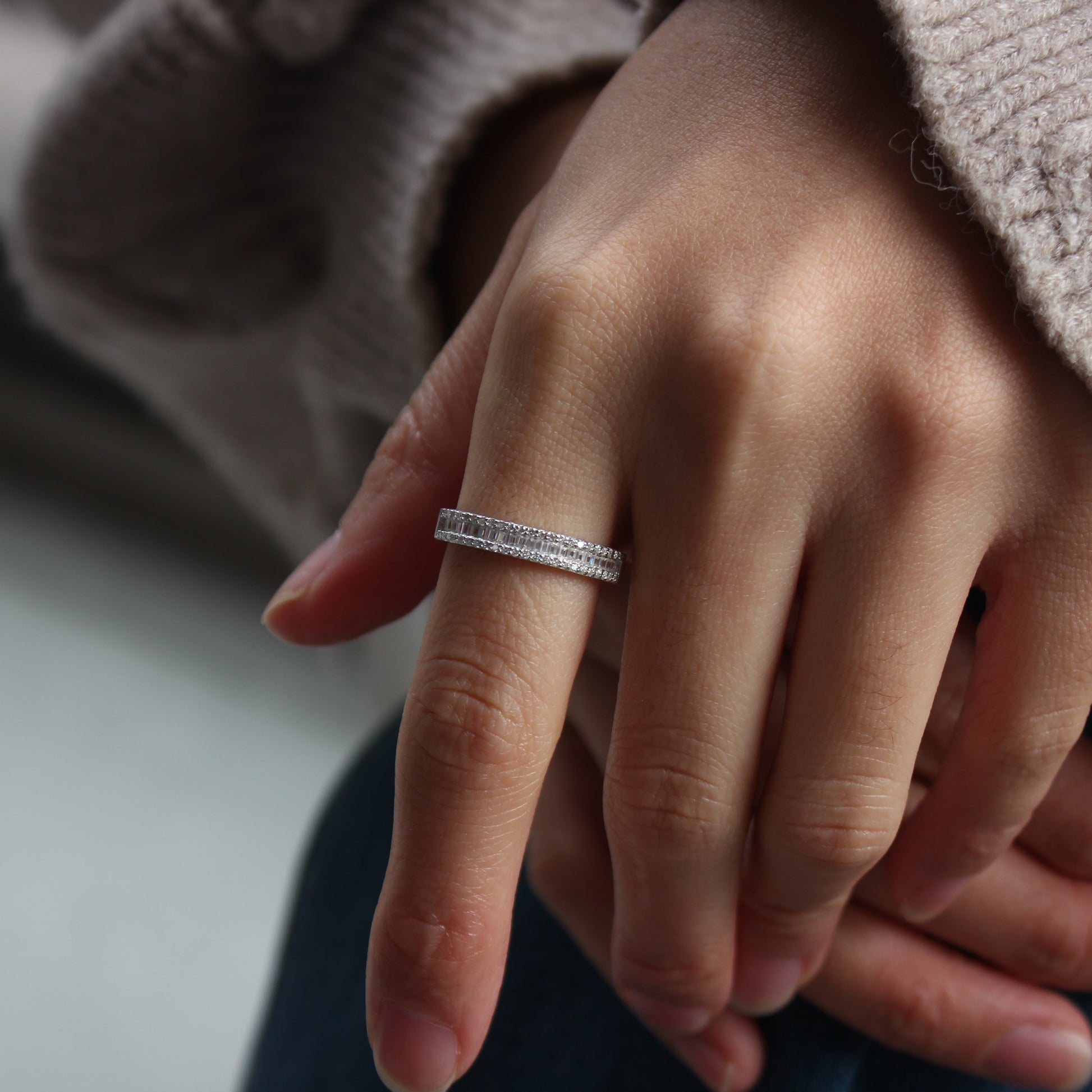Minimal pavé moissanite band ring worn on hand, white gold tone aesthetic