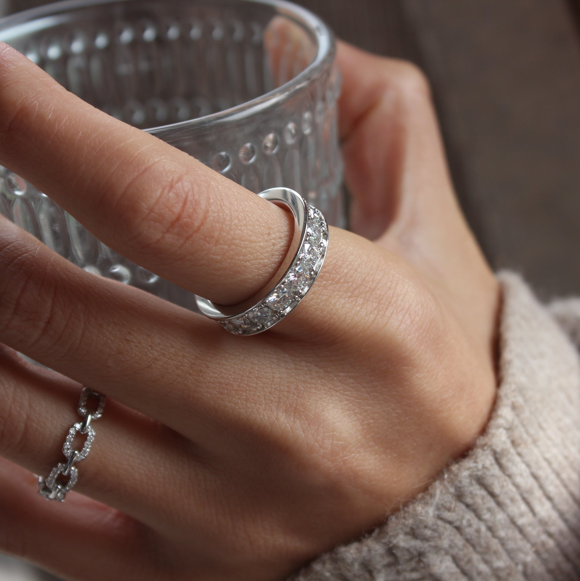 Celeste moissanite band ring styled on hand, white gold tone stacking look