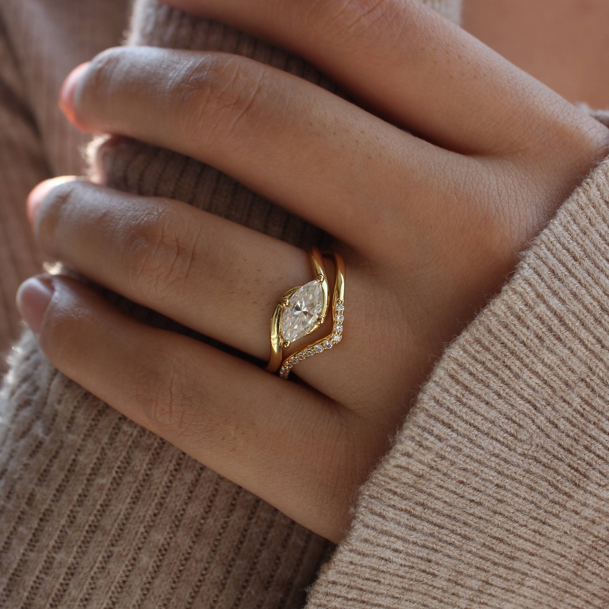 Curved pavé moissanite ring set styled on hand with knit sleeve