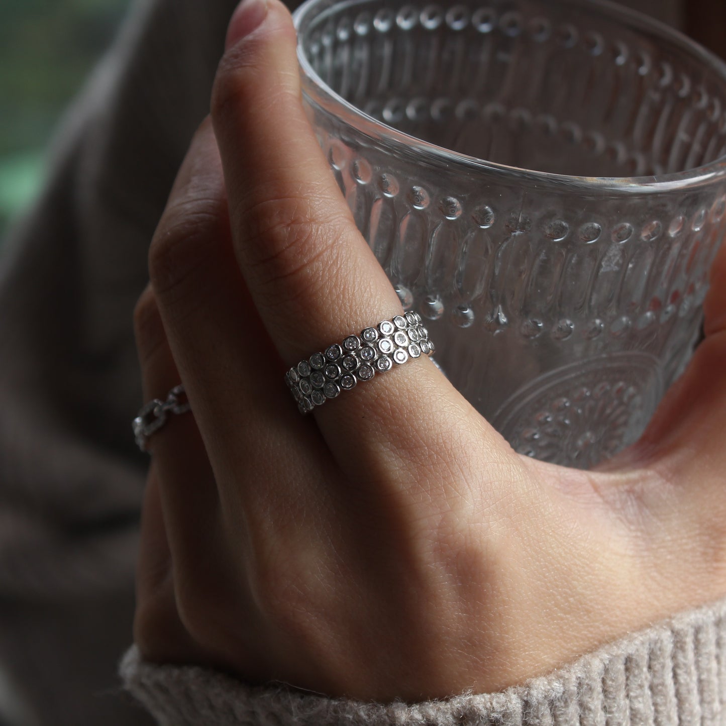 Woman wearing dome pavé moissanite ring in white gold tone, bold yet elegant look
