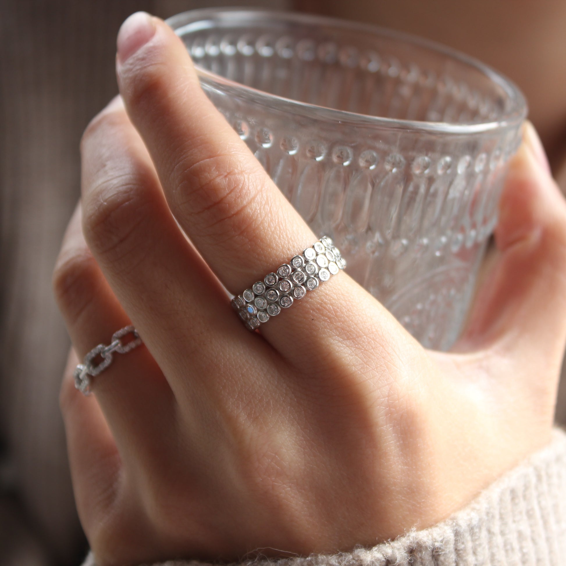 Lifestyle hand photo featuring dome pavé moissanite ring