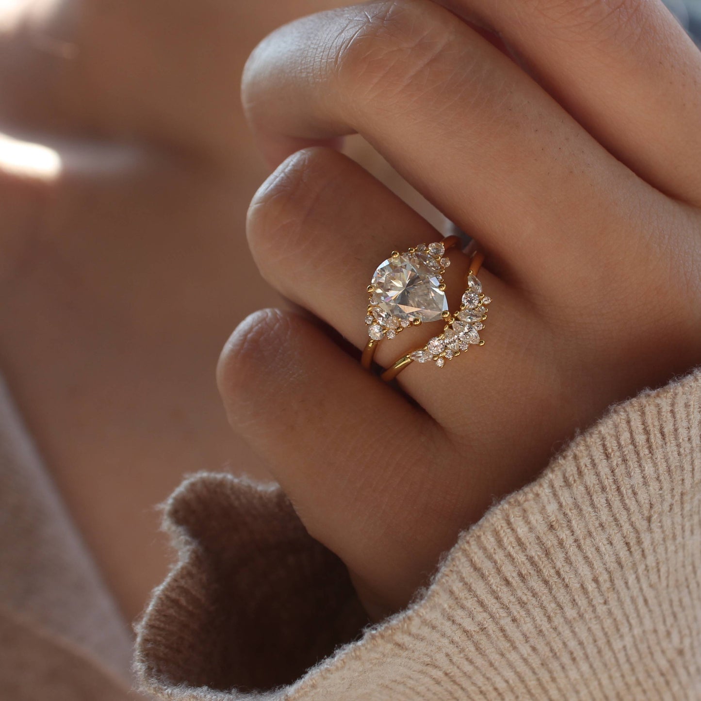Duo pear-cut moissanite ring set worn on hand in warm natural light