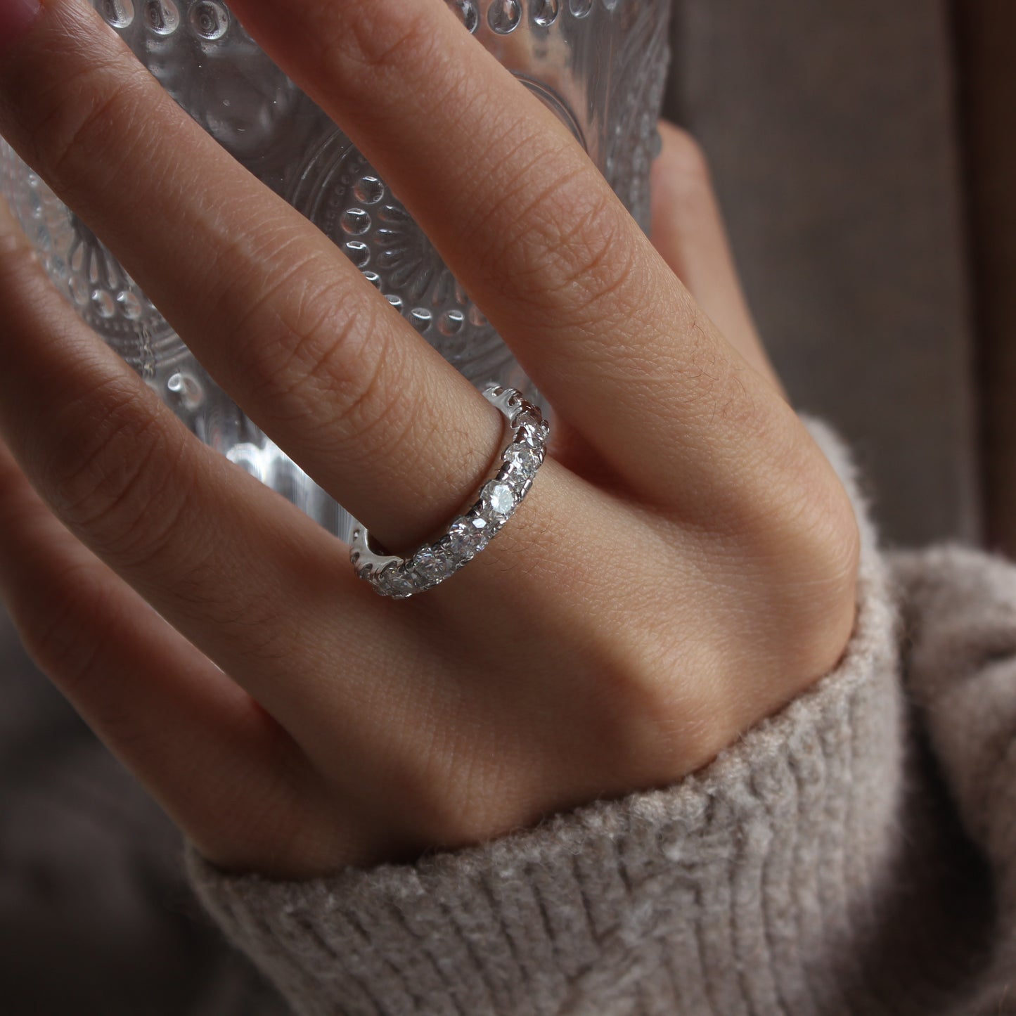 Soft feminine styling of Elara eternity moissanite band ring worn on finger