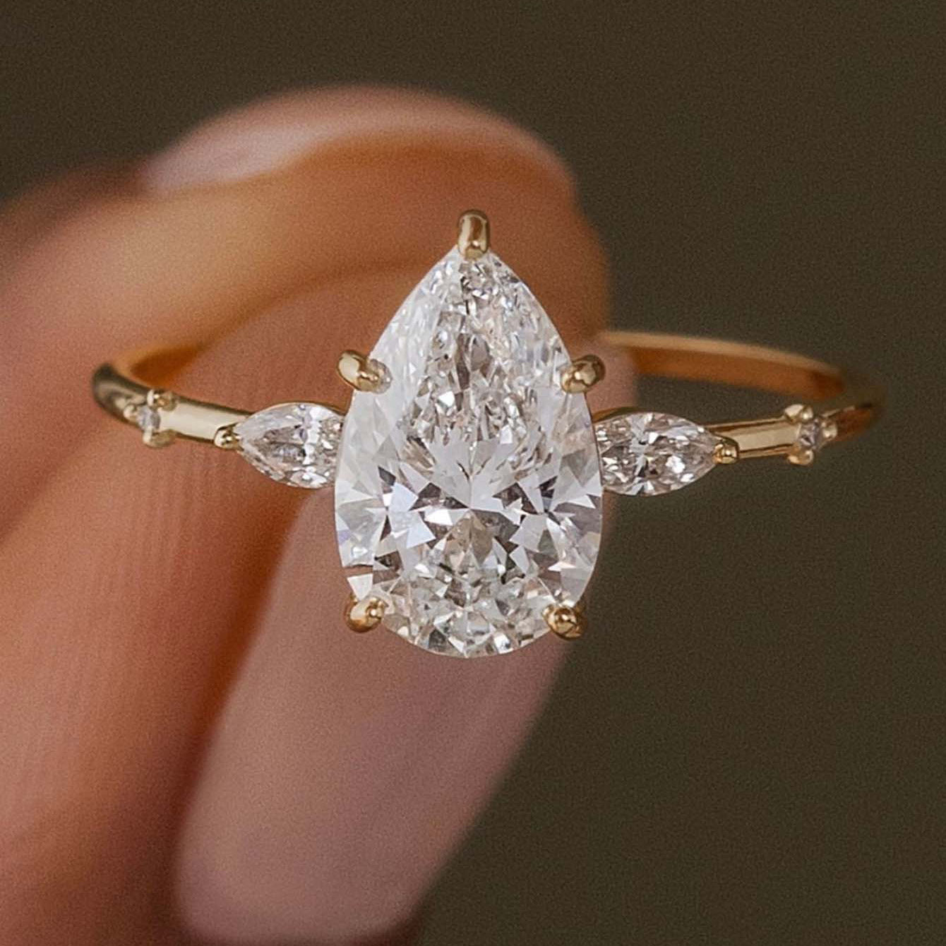 Close view of elara pear moissanite ring on finger