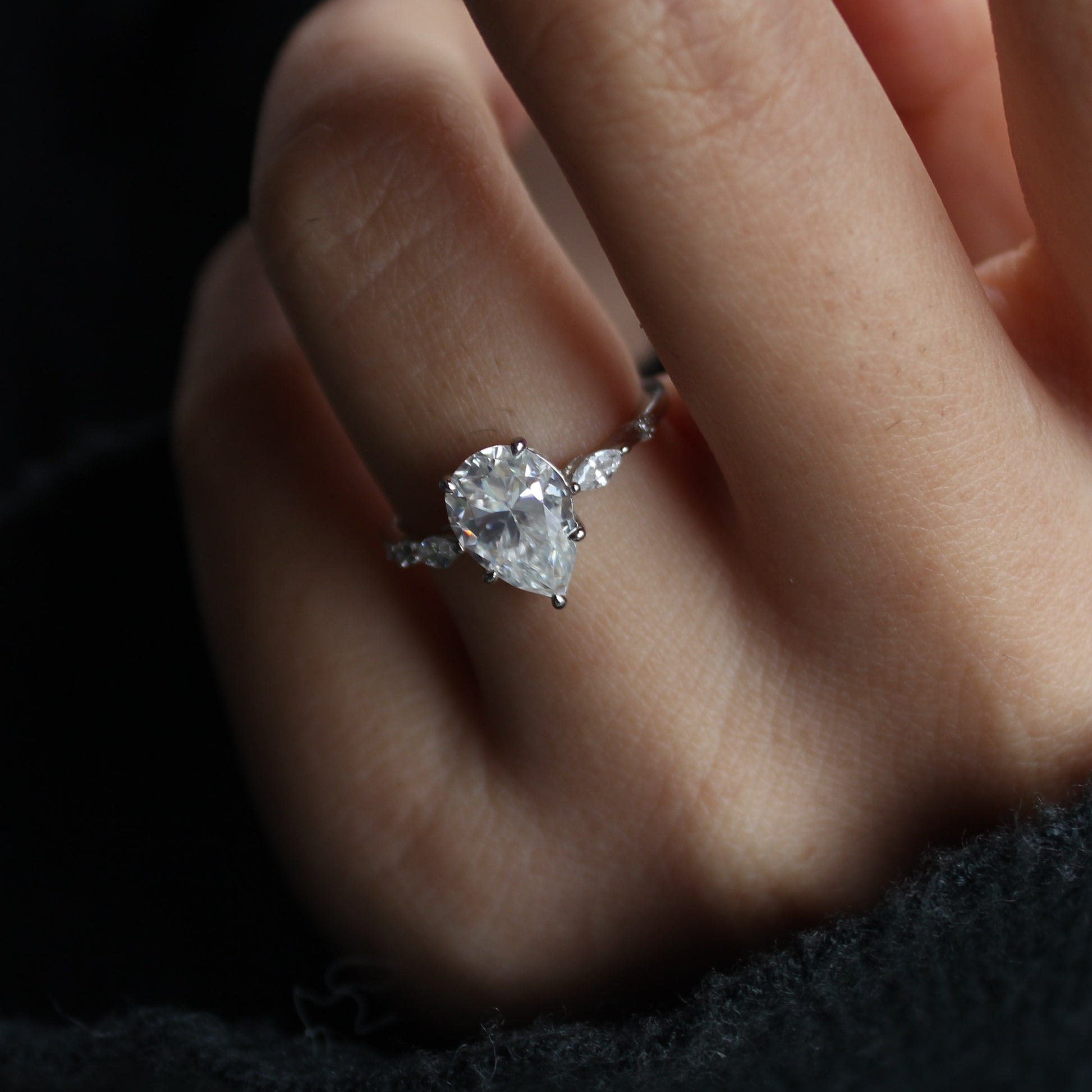 Elara pear moissanite ring on finger elegant pose
