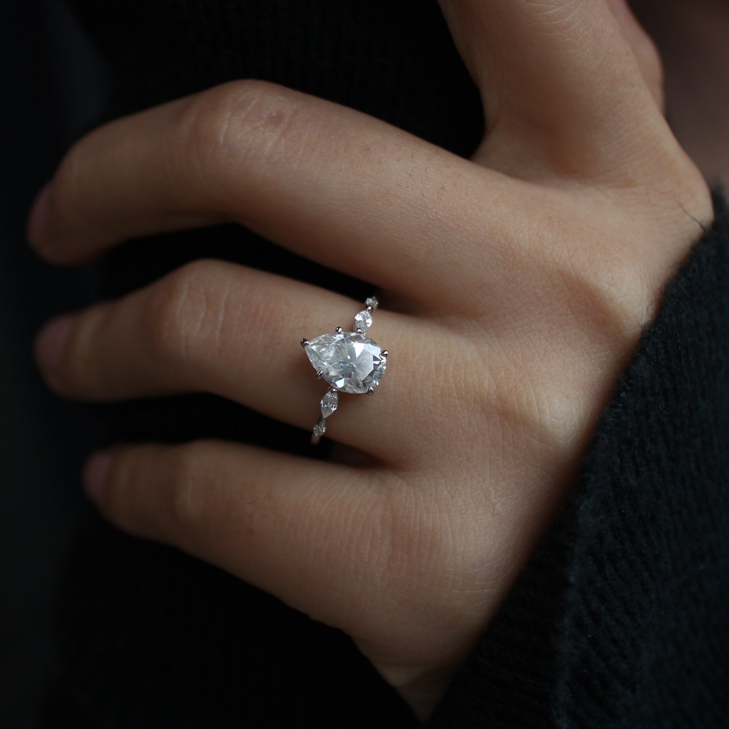 Elara pear moissanite ring on finger elegant pose