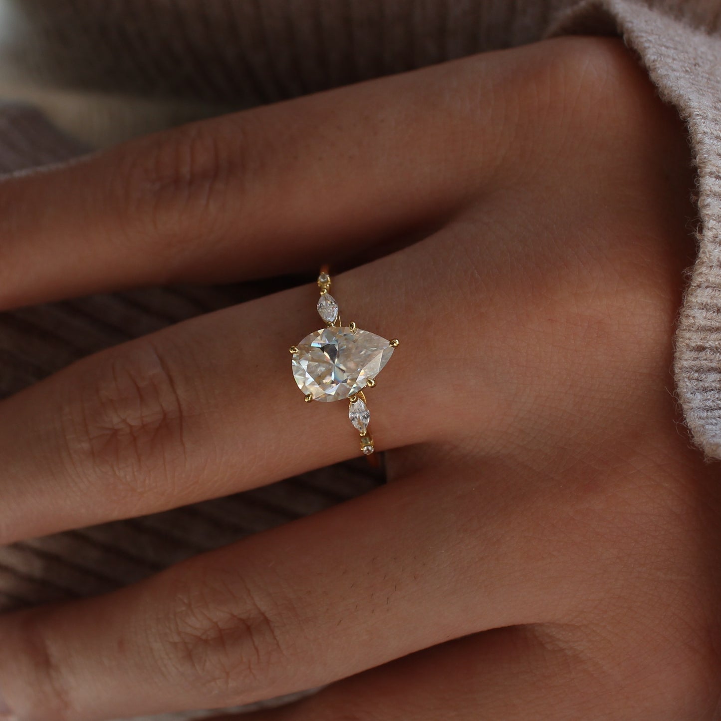 Elara pear moissanite ring worn on hand in soft light