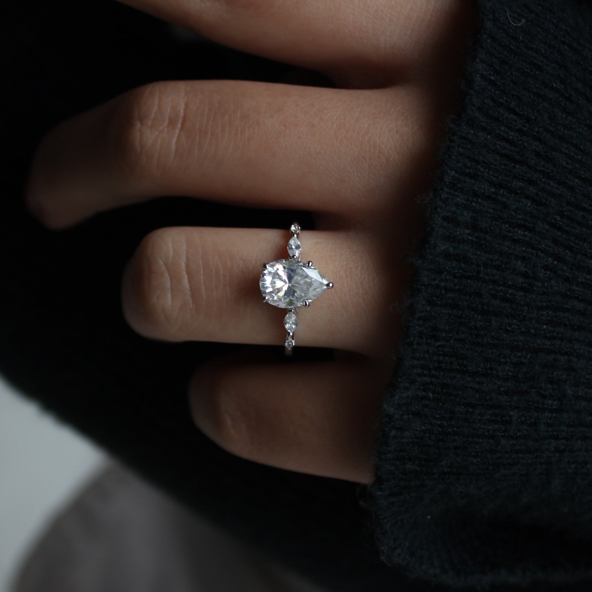 Elara pear moissanite ring worn on hand close framing