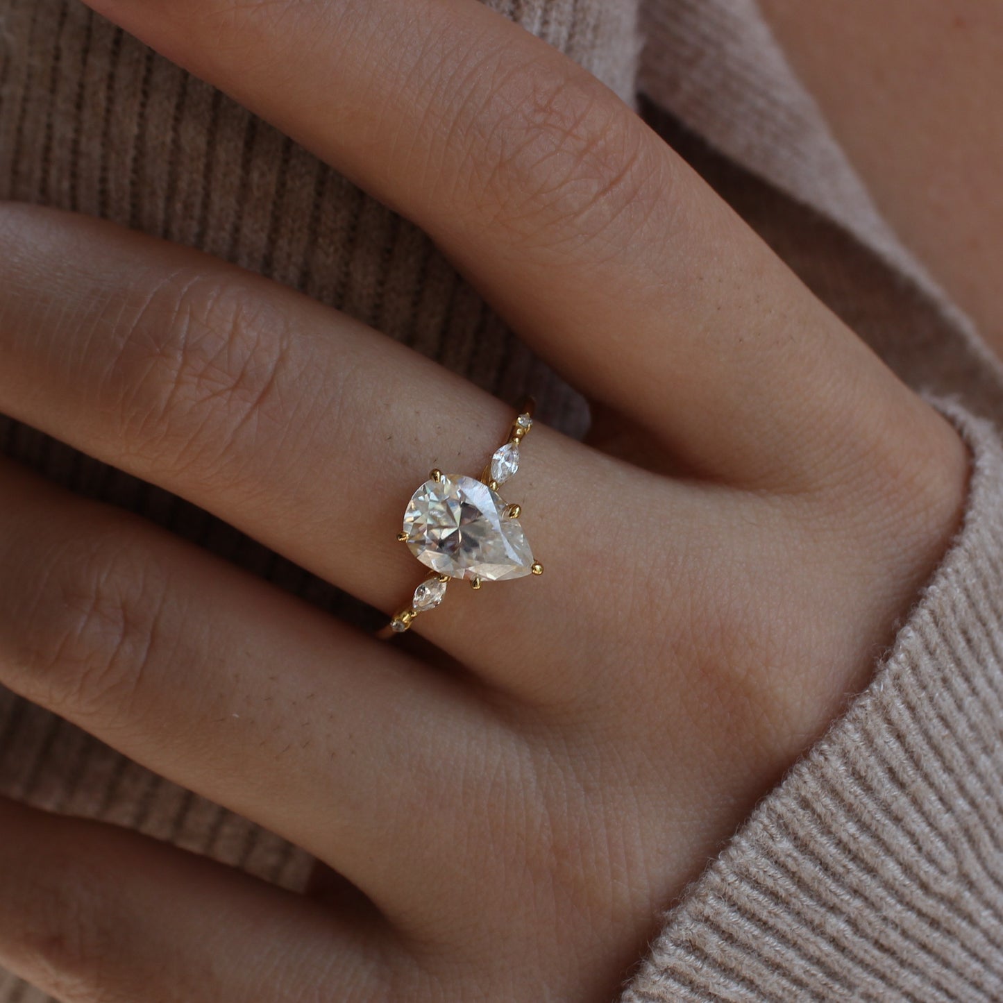 Elara pear moissanite ring shown on hand