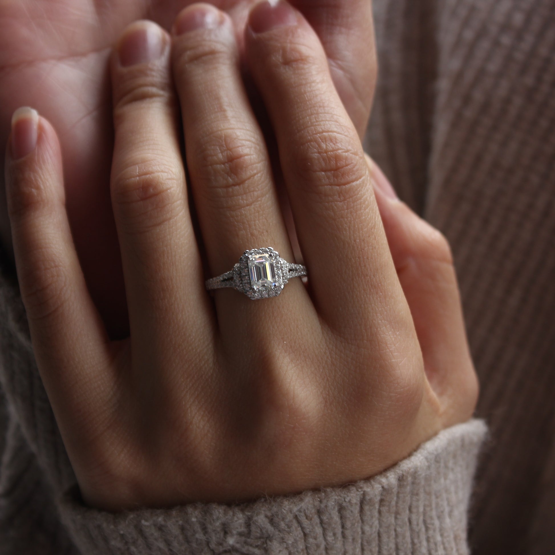 Halo emerald cut moissanite ring on hand, white gold tone with refined sparkle