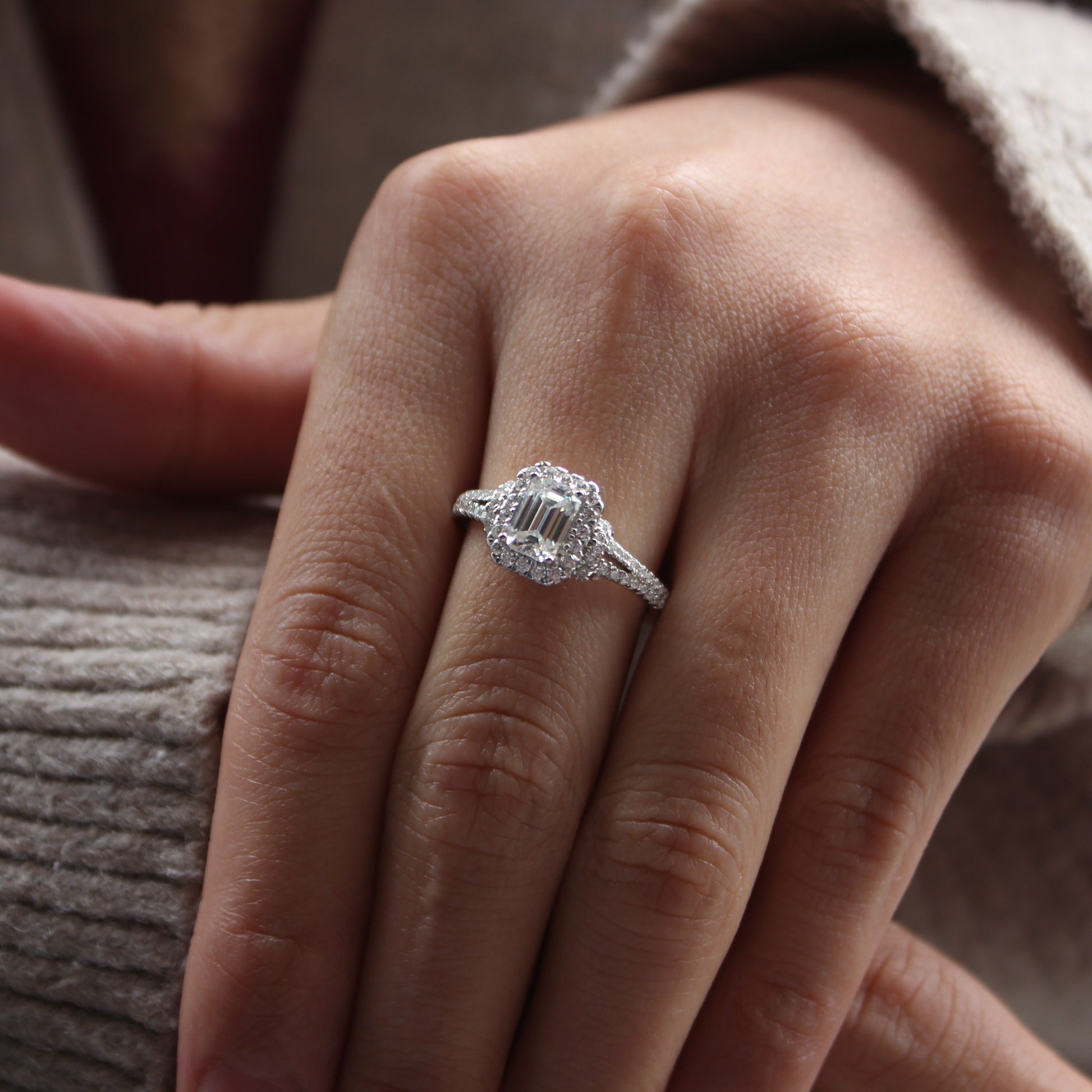 Emerald cut halo moissanite ring styled on hand, white gold tone stacking look