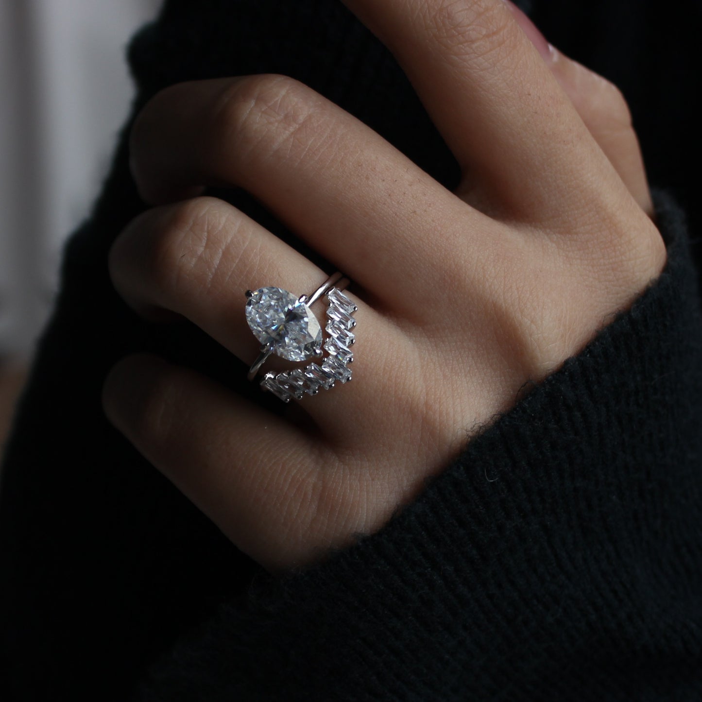 Geometric cluster moissanite ring worn on hand, dark background