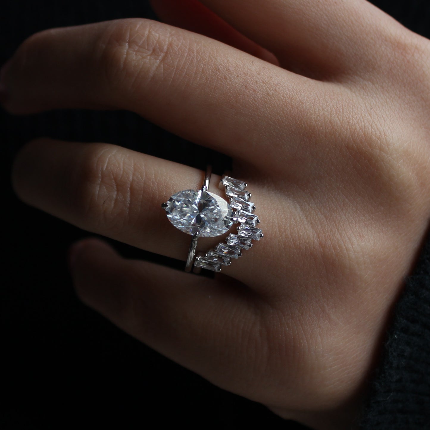 Geometric cluster moissanite ring worn on hand, dramatic lighting