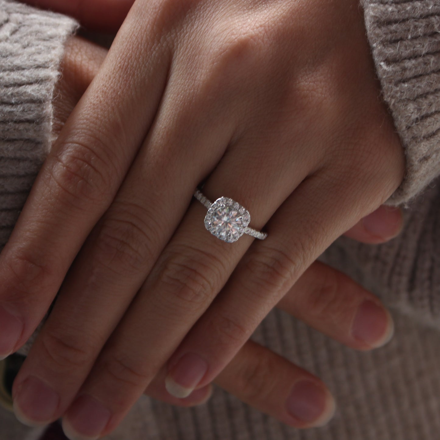 Halo pavé moissanite ring in white gold tone worn on hand, delicate halo style