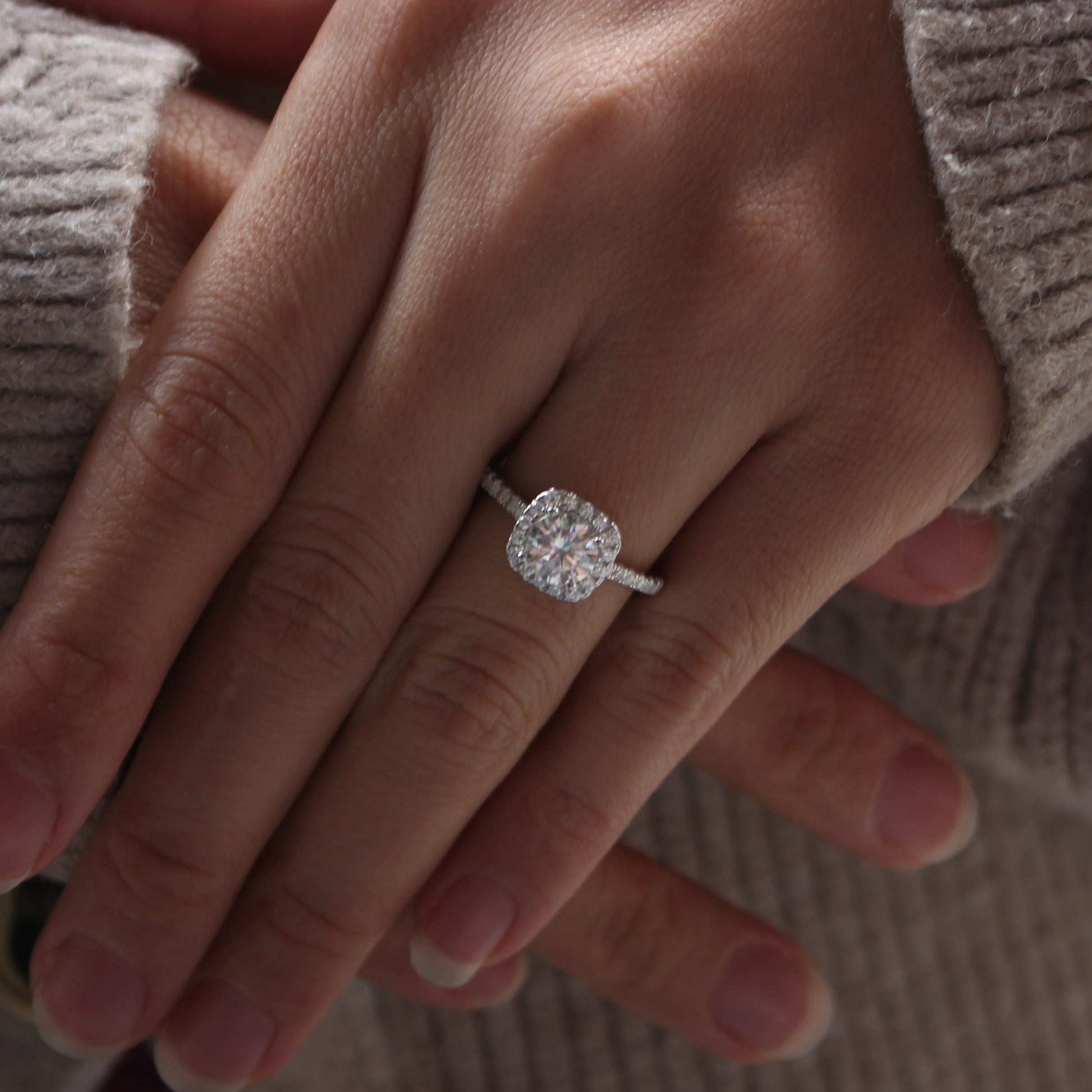 Halo pavé moissanite ring in white gold tone worn on hand, delicate halo style