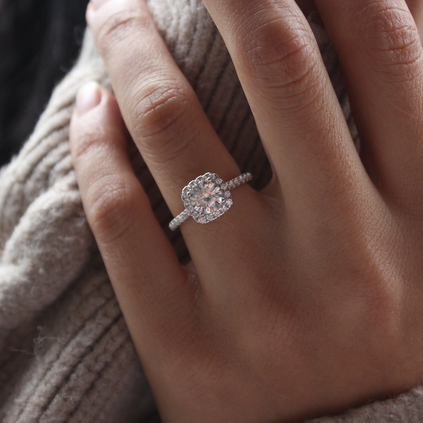 Pavé halo moissanite ring on hand, white gold tone with brilliant sparkle