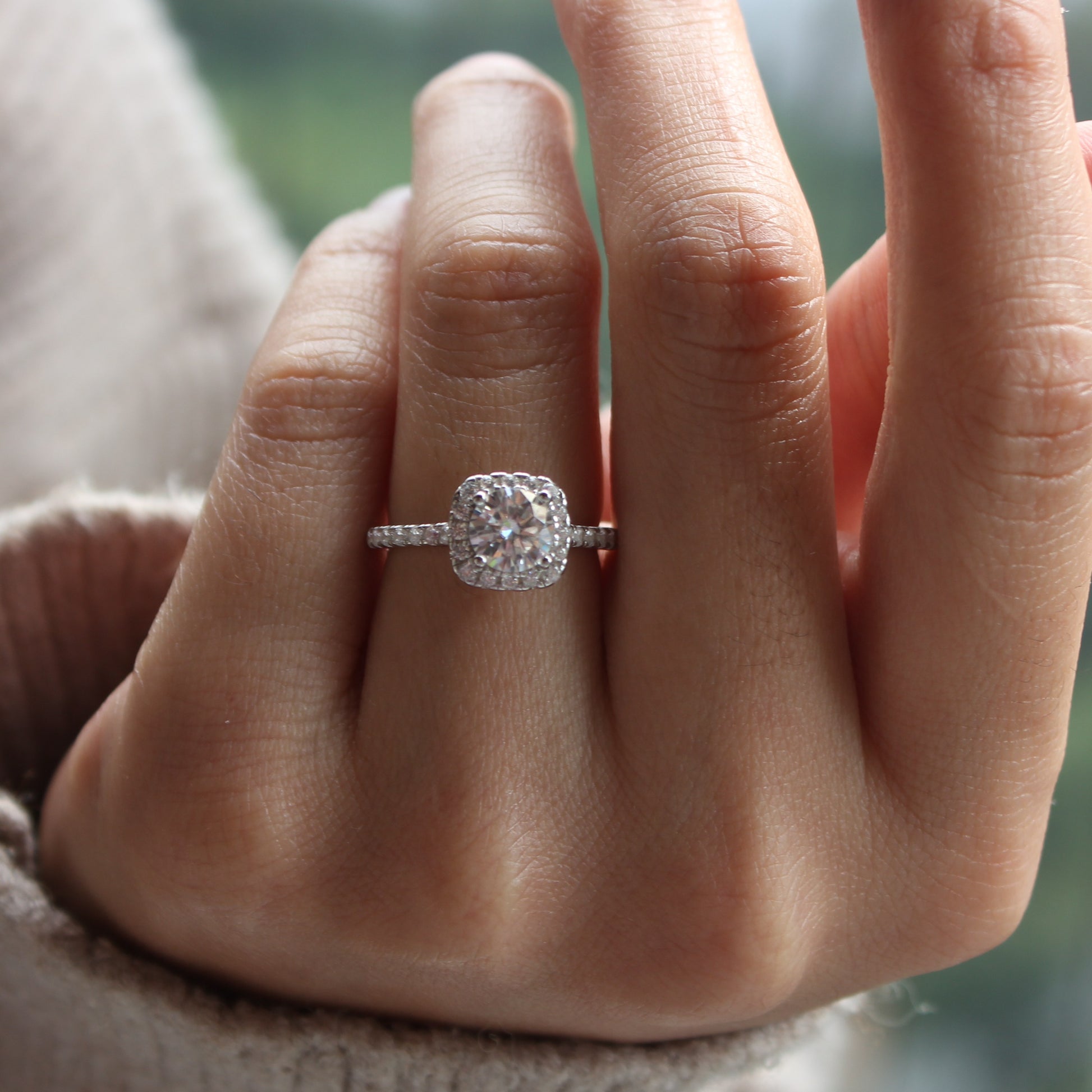 Halo moissanite ring styled on hand, white gold tone for everyday wear