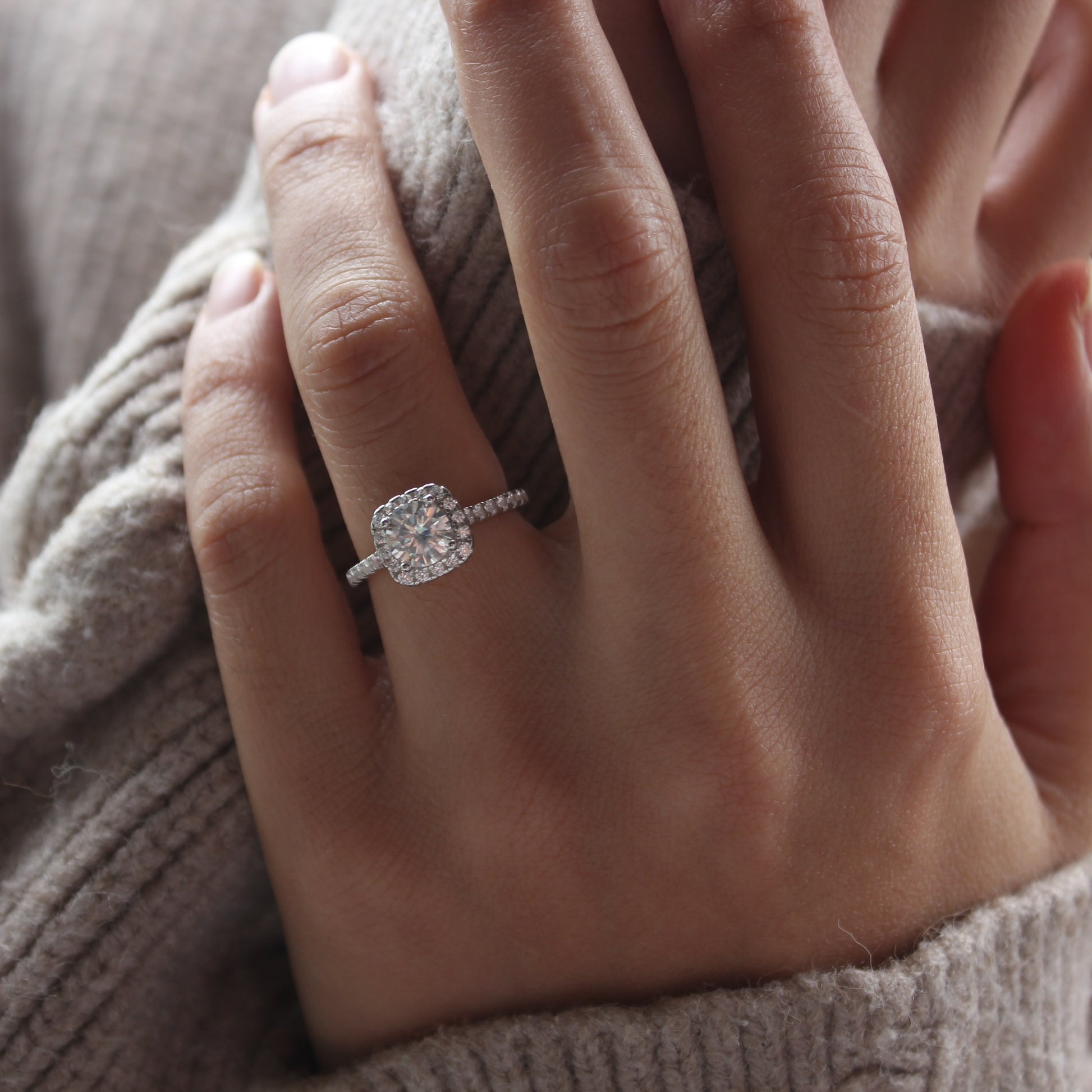 Halo pavé moissanite ring styled on hand, white gold tone look