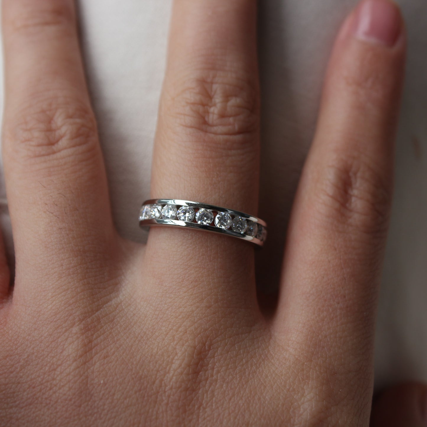 Close-up of Liora moissanite band ring worn on finger, refined everyday look