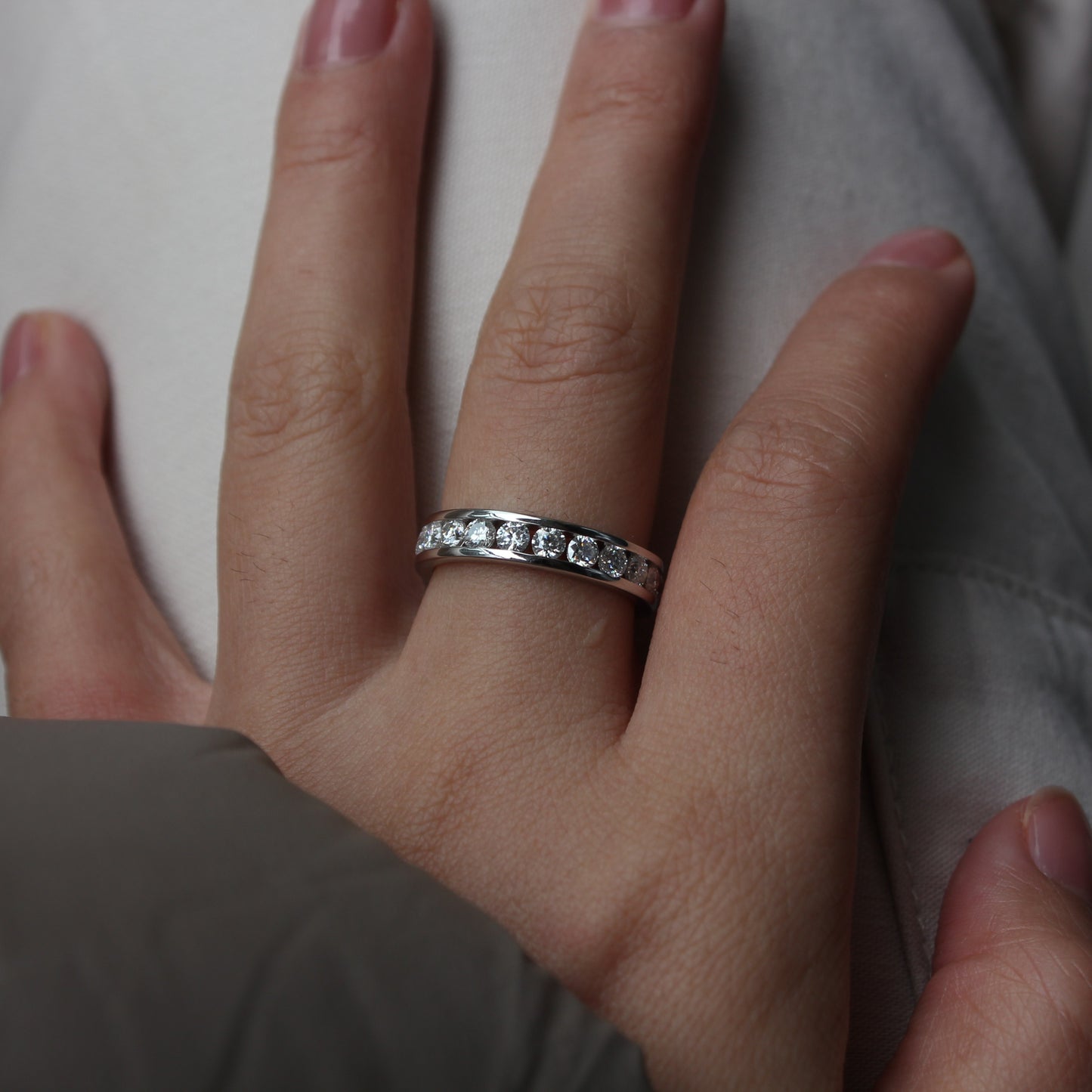 Elegant white gold tone moissanite band ring worn in natural daylight