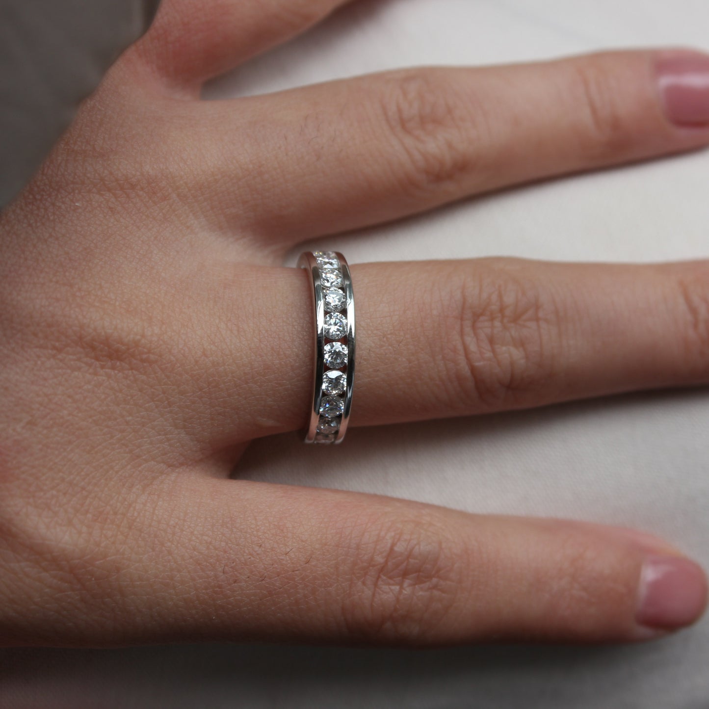  Soft feminine styling of Liora moissanite band ring worn on finger