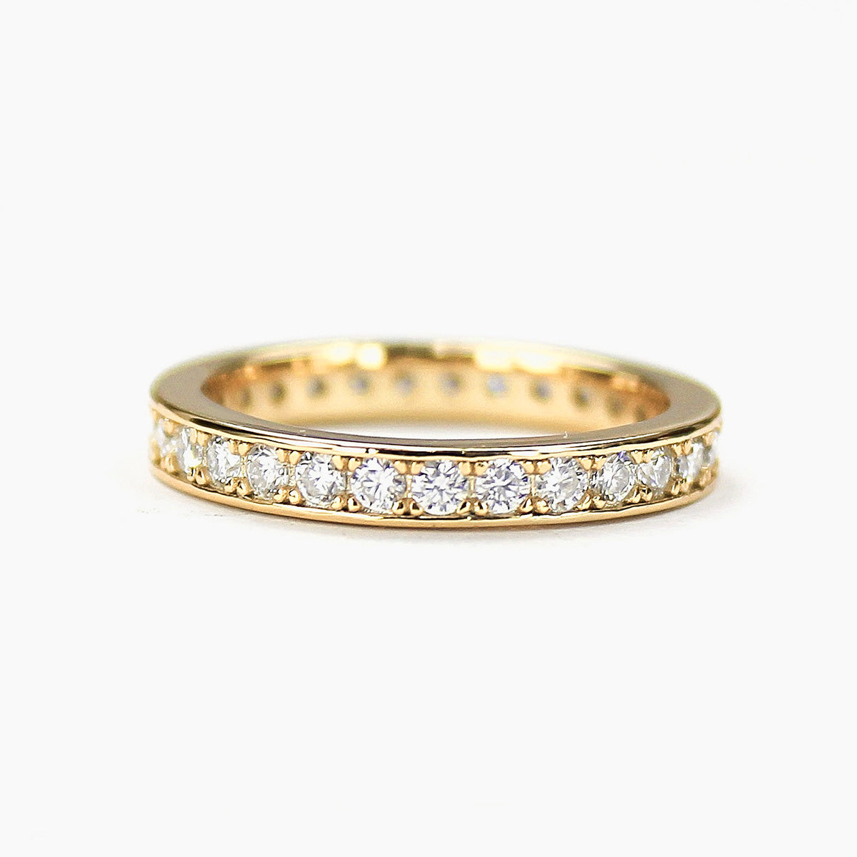 Moissanite eternity band in 18K gold plated sterling silver on white background
