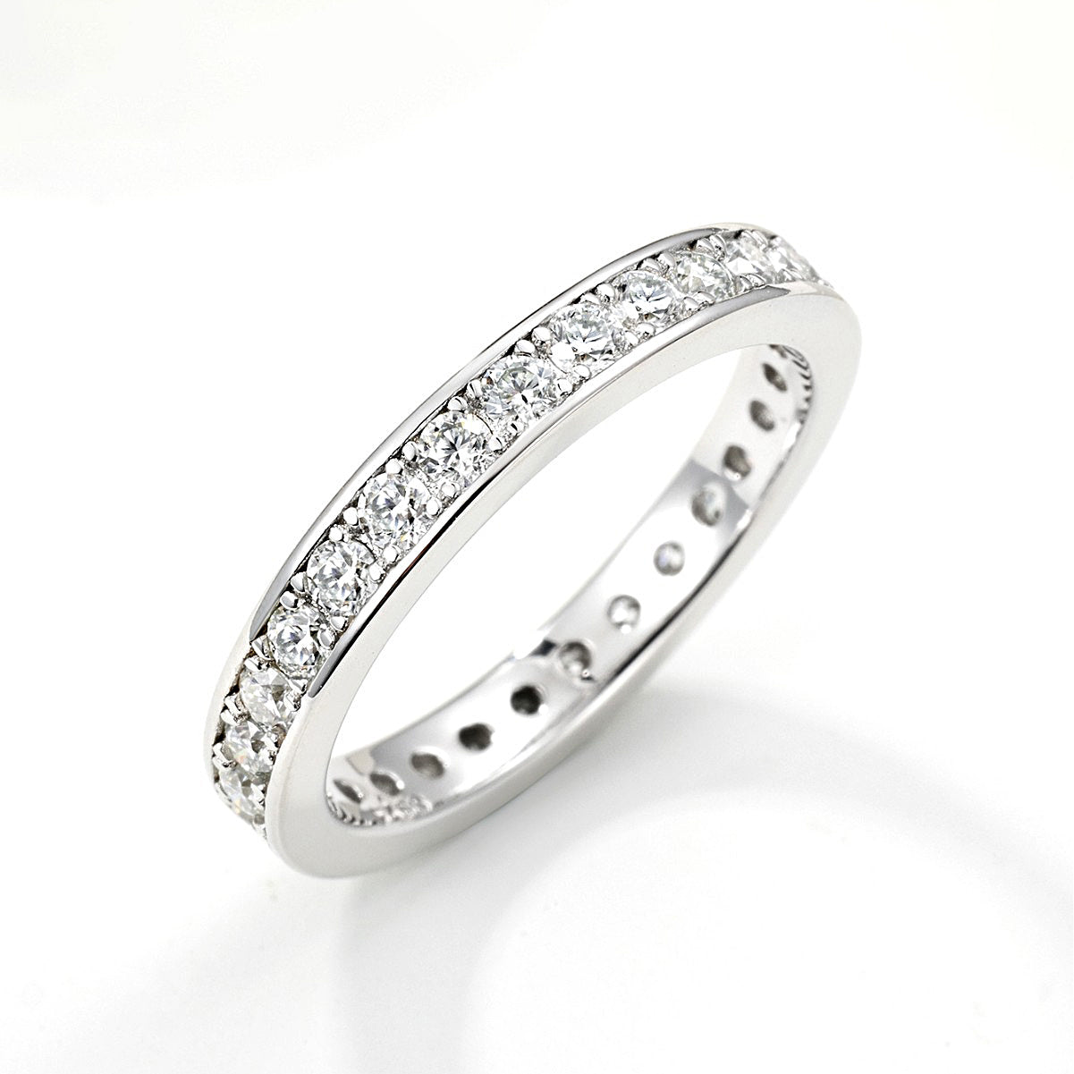 Side view of moissanite eternity band in silver tone on white background