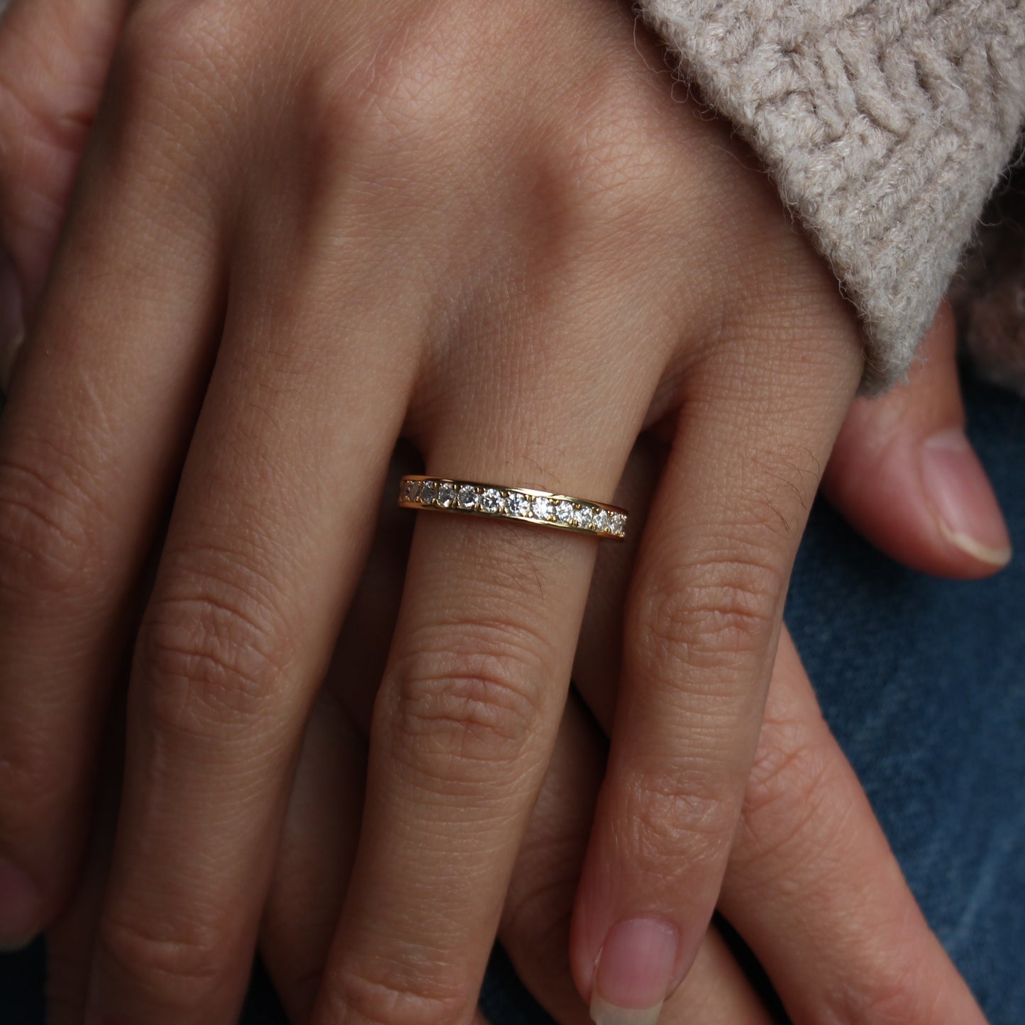 Moissanite eternity band worn on finger