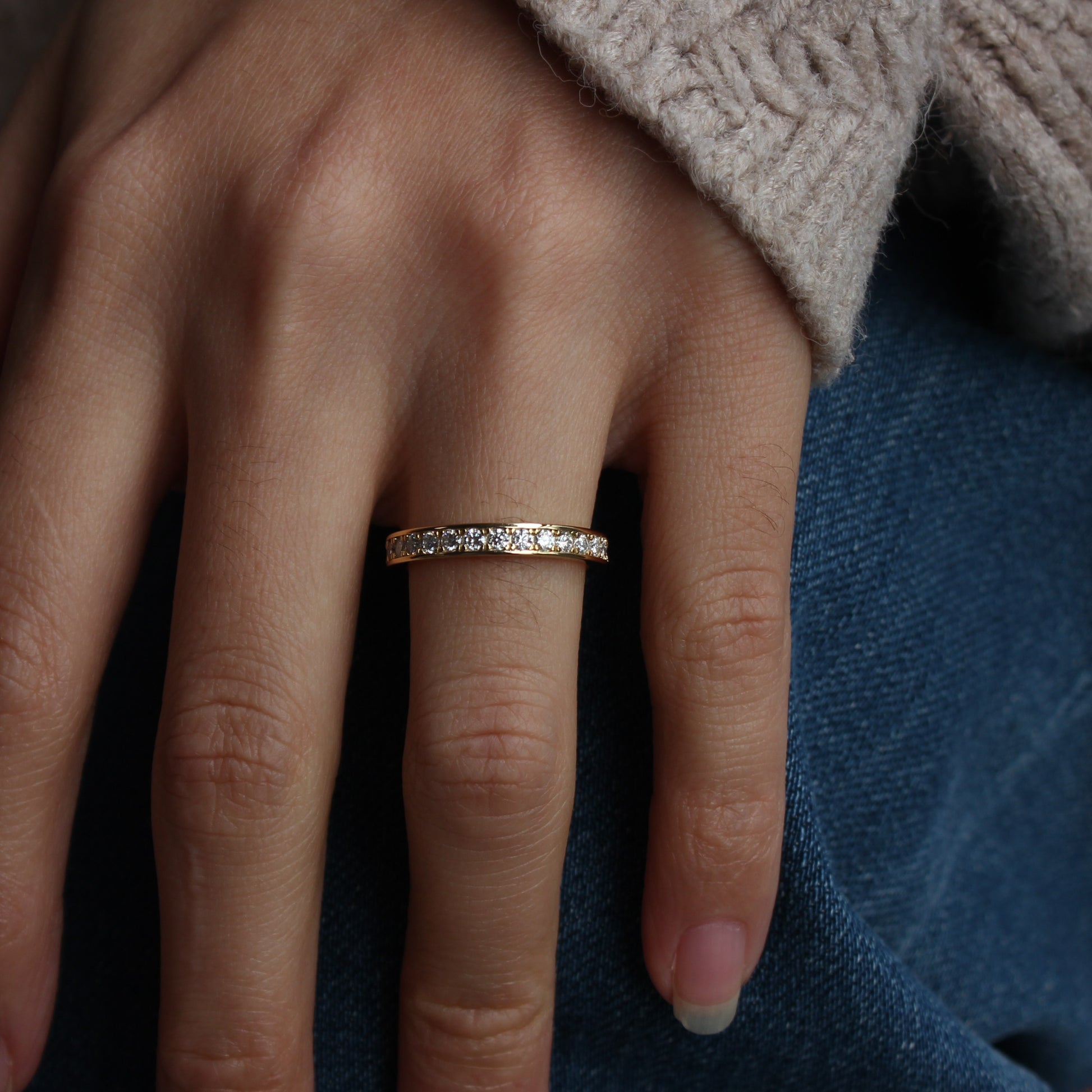 Moissanite eternity band worn in casual hand pose