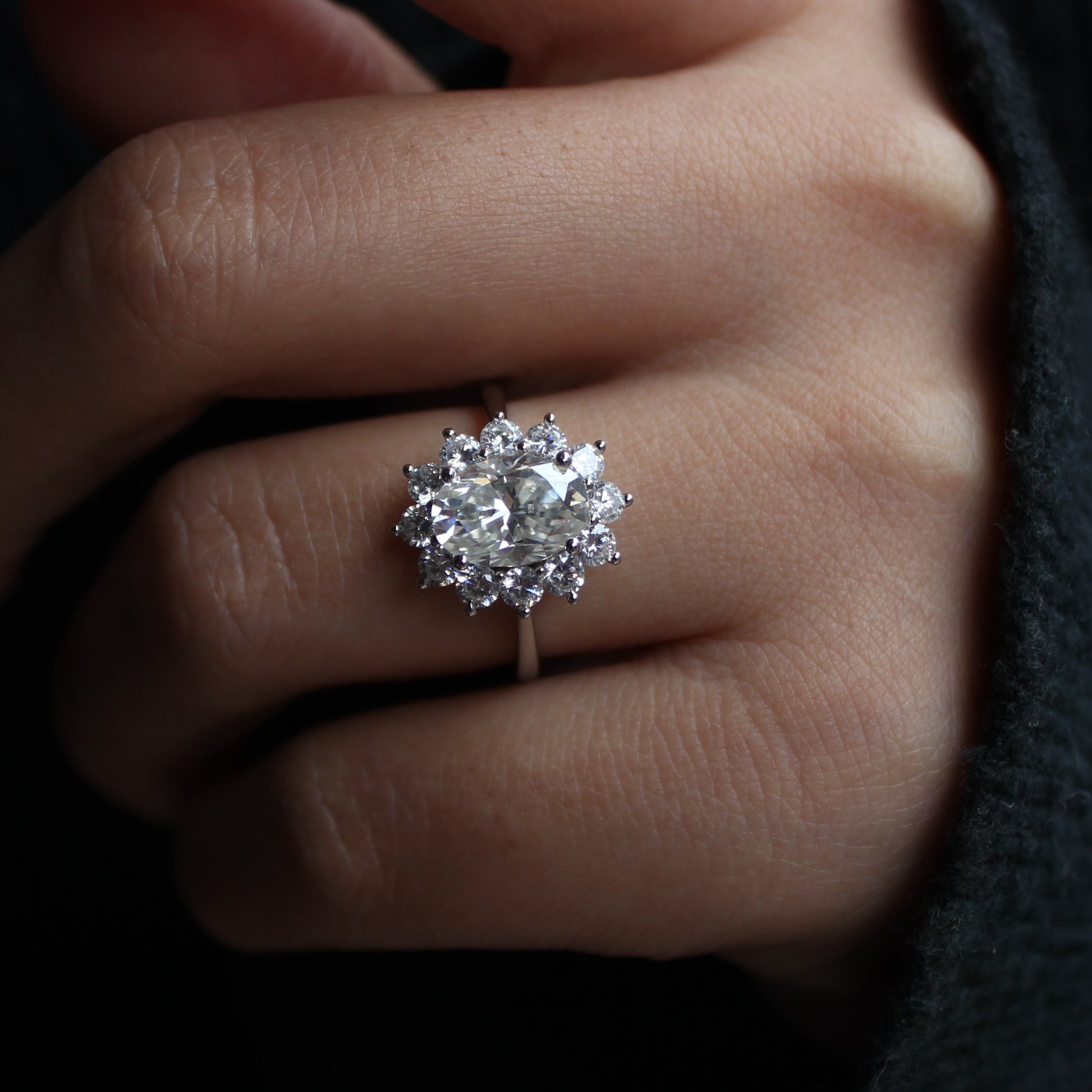 Oval cut moissanite halo ring worn on hand, elegant look