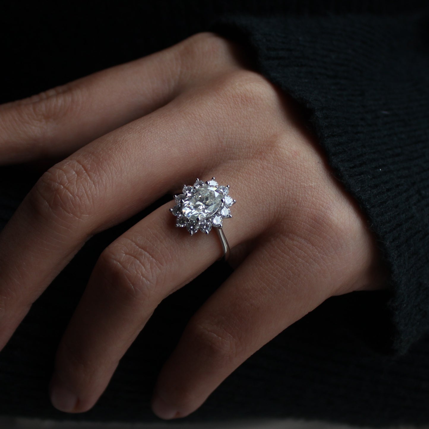 Brilliant oval halo moissanite ring worn on hand, evening light
Filename: