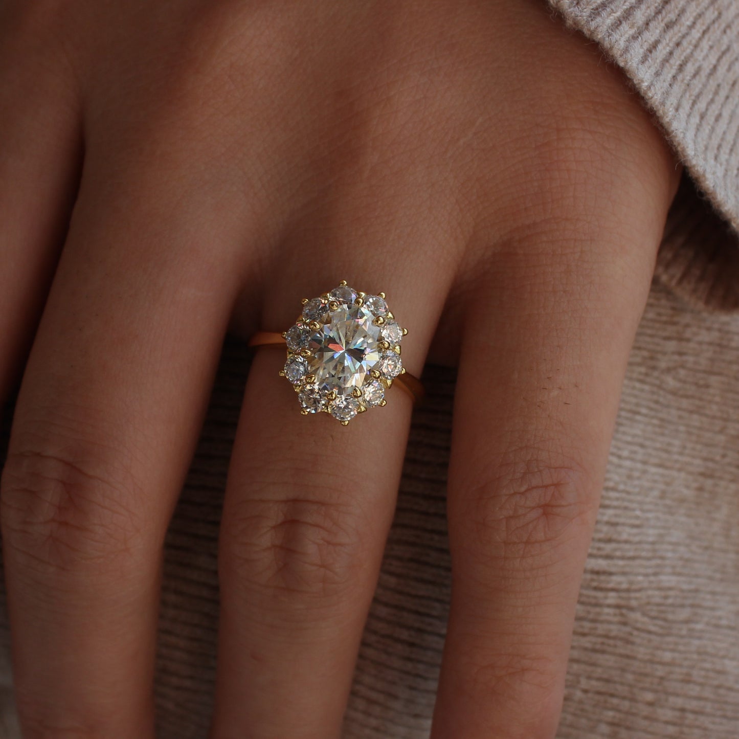 Halo moissanite engagement style ring worn on hand, gold tone