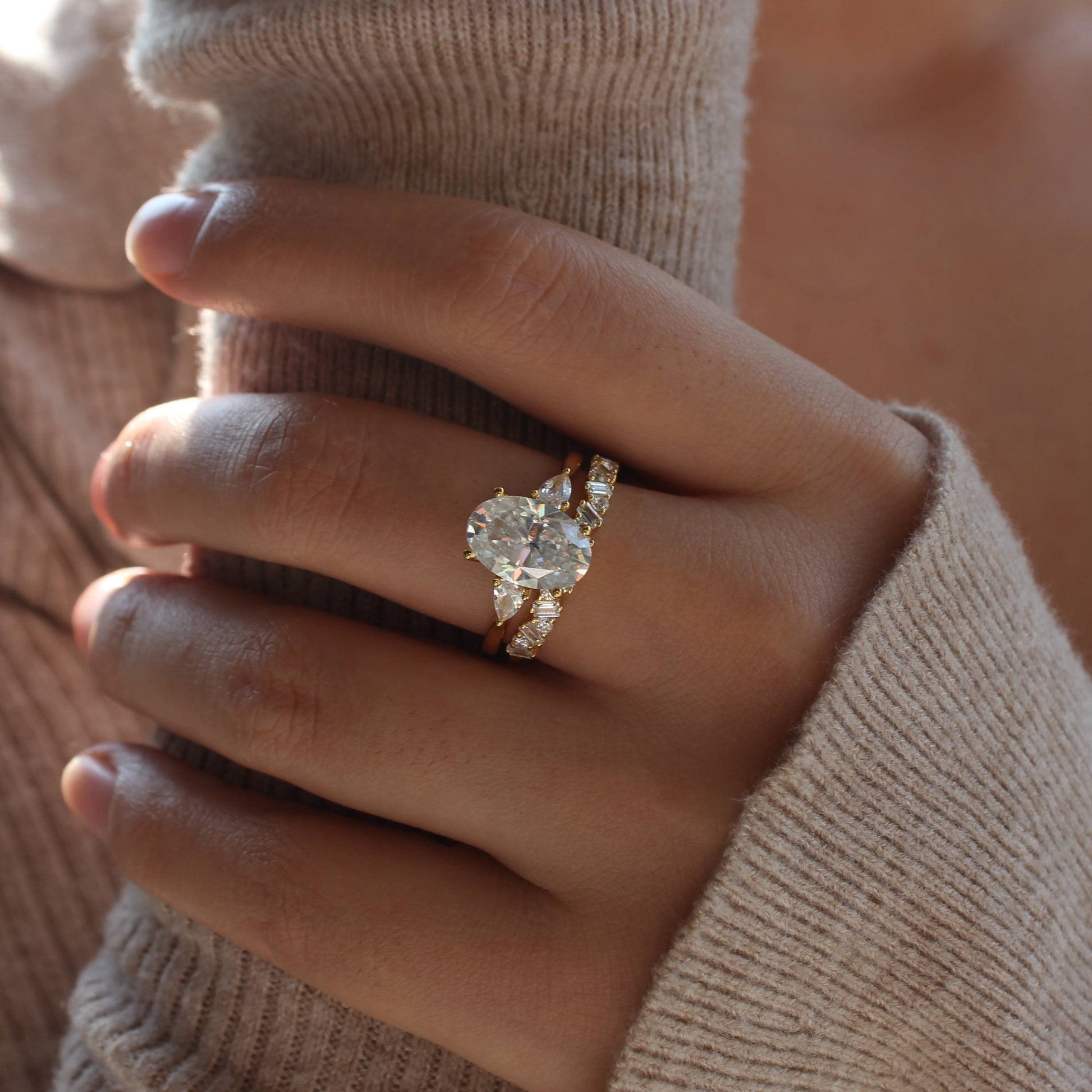 Oval moissanite duo stacking rings worn on hand, warm natural light
