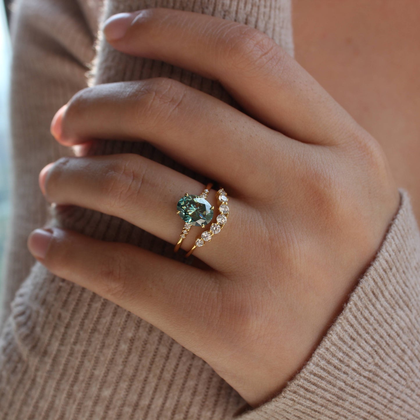 Minimalist styling of oval moissanite ring set worn on finger