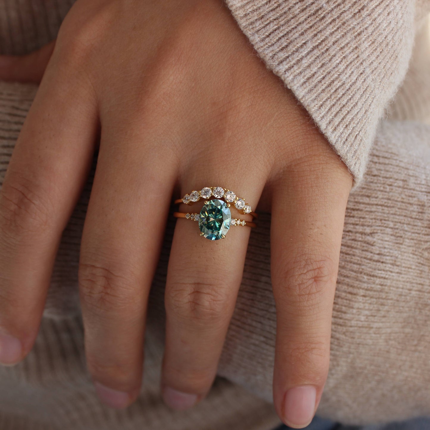 Moody close-up of oval moissanite stackable rings on hand