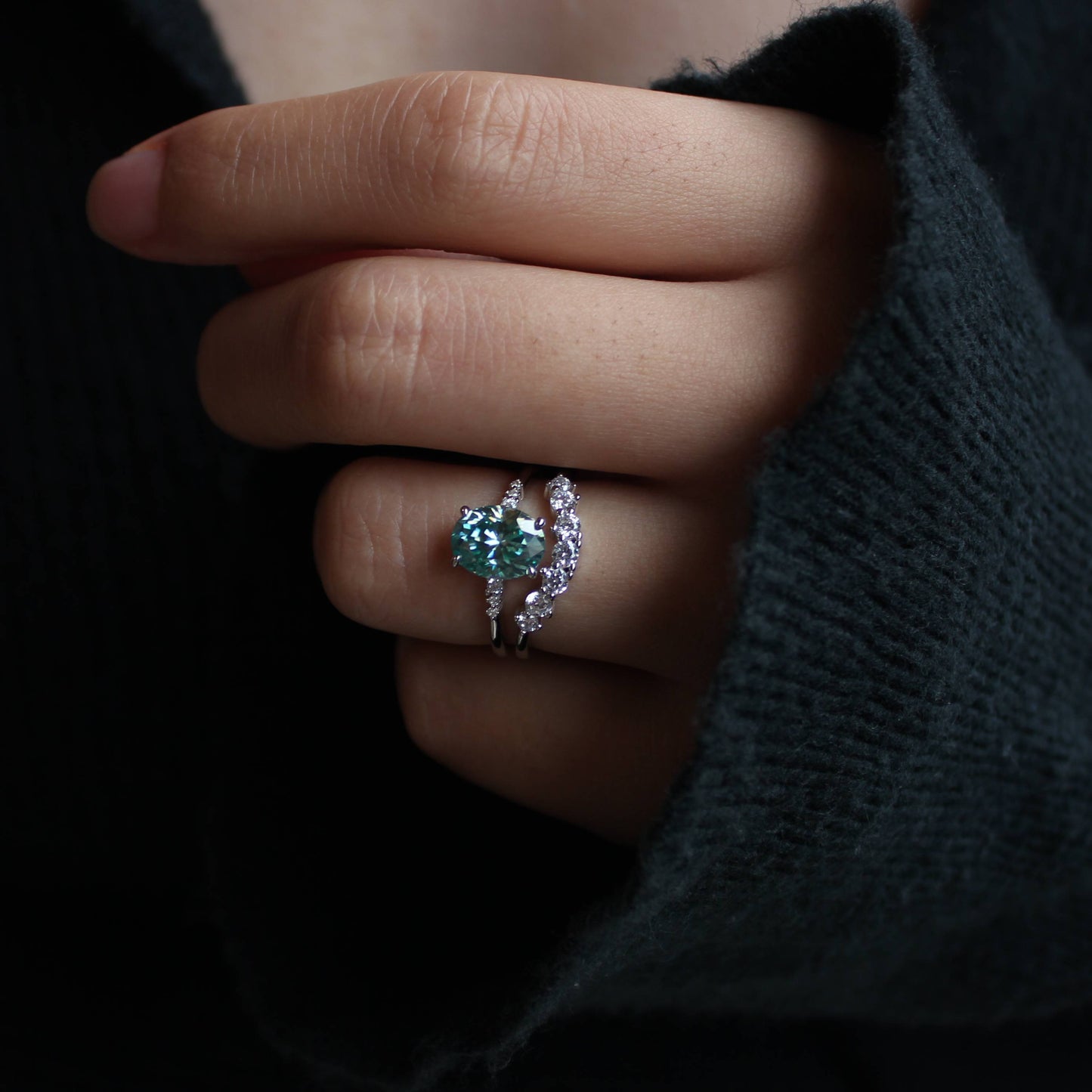 Elegant close-up of oval moissanite ring set worn on finger