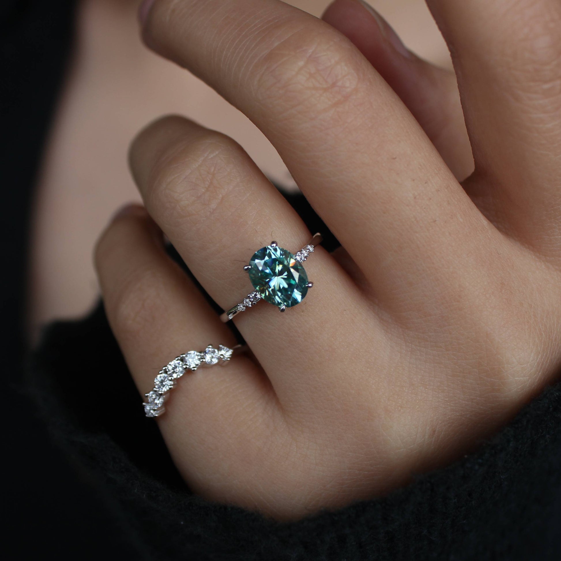 Modern hand styling featuring oval moissanite statement ring set