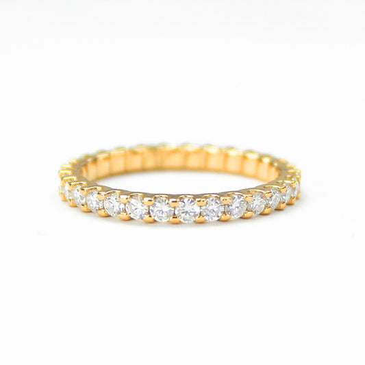 Shared prong moissanite eternity band in 18K gold plated sterling silver on white background