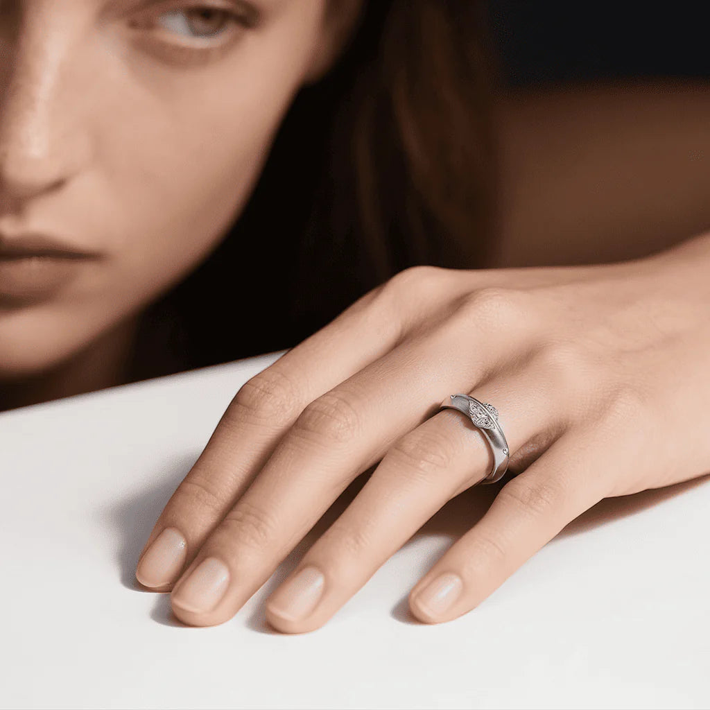 Rotatable solitaire moissanite ring on hand, white gold tone with subtle sparkle