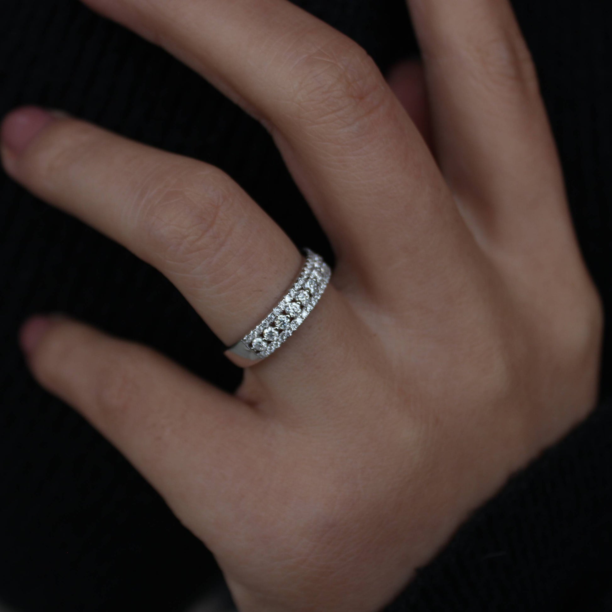 Lifestyle photo of triple pavé moissanite statement band worn on fingers